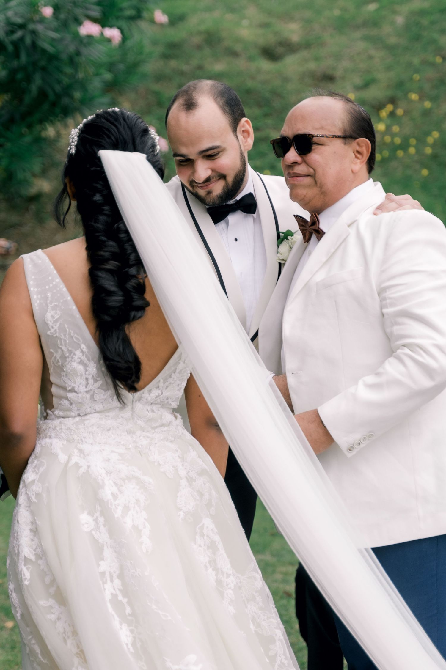A romantic sequence of wedding photos showing a couple in white attire embracing outdoors with a natural green backdrop.