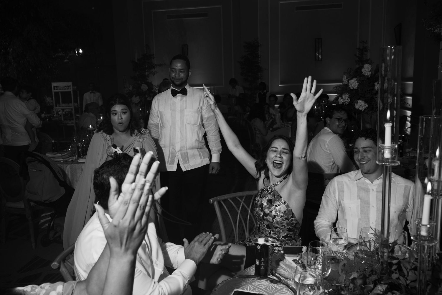 Wedding reception dance floor filled with guests celebrating under dimmed lighting and decorative elements.