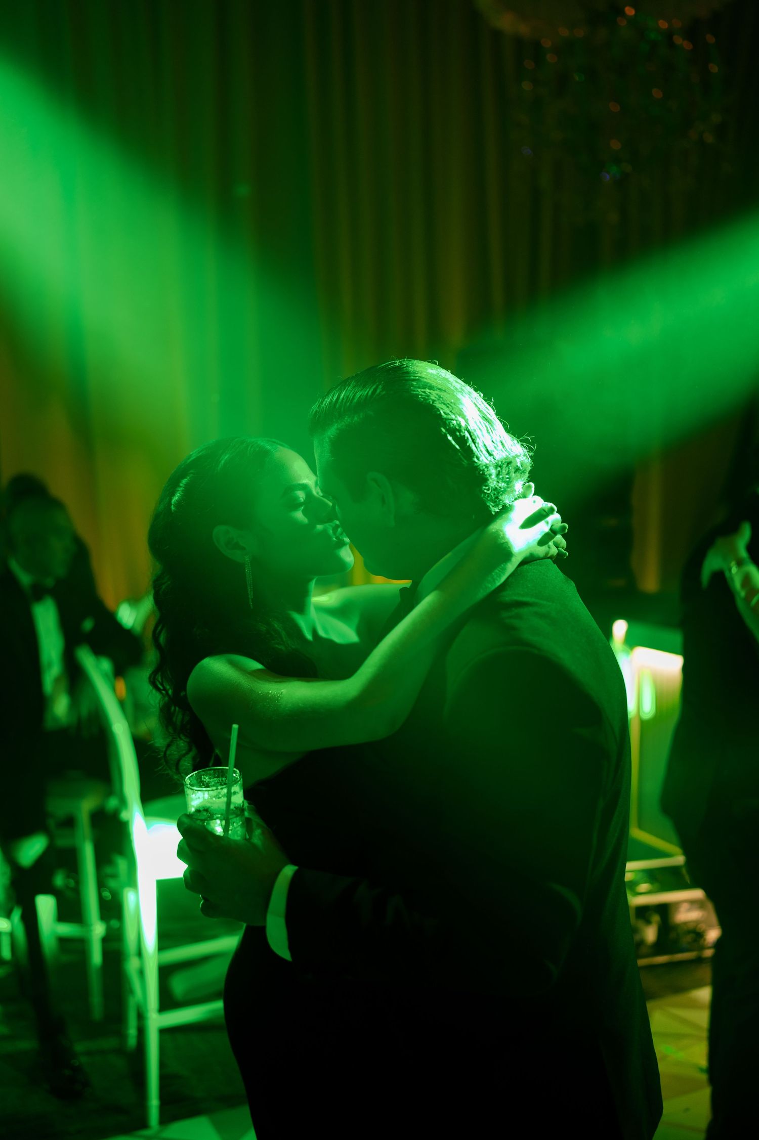 Silhouettes of performers on stage bathed in dramatic green lighting create an atmospheric concert scene.