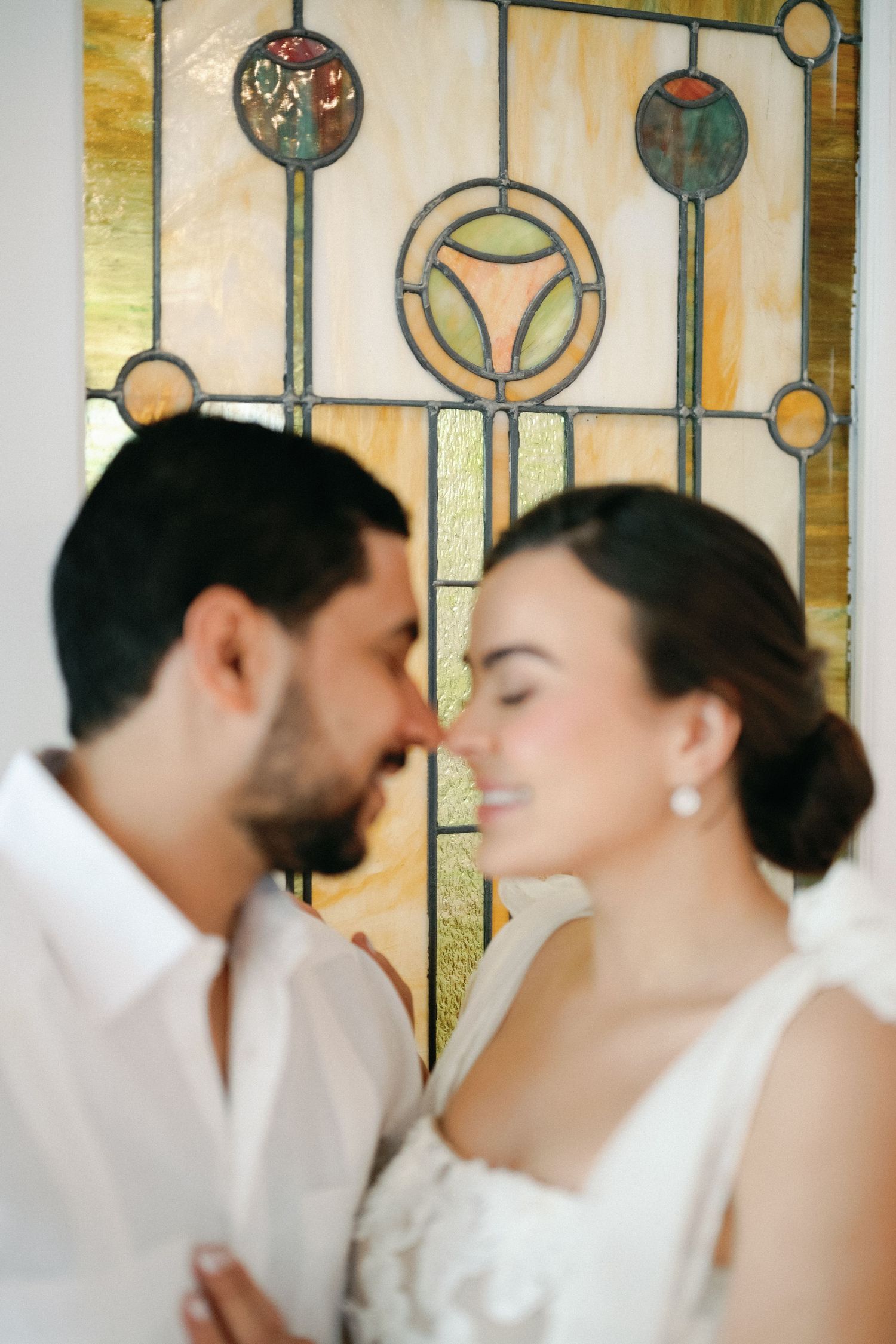 Artistic wedding portraits against stained glass window panels.