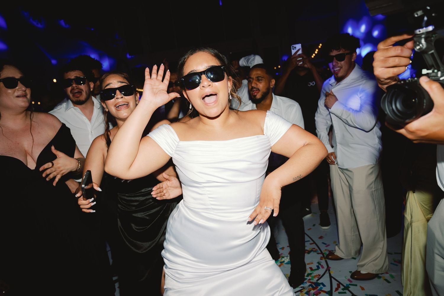 A sequence of party photos showing people dancing and celebrating in a dimly lit venue with blue lighting.
