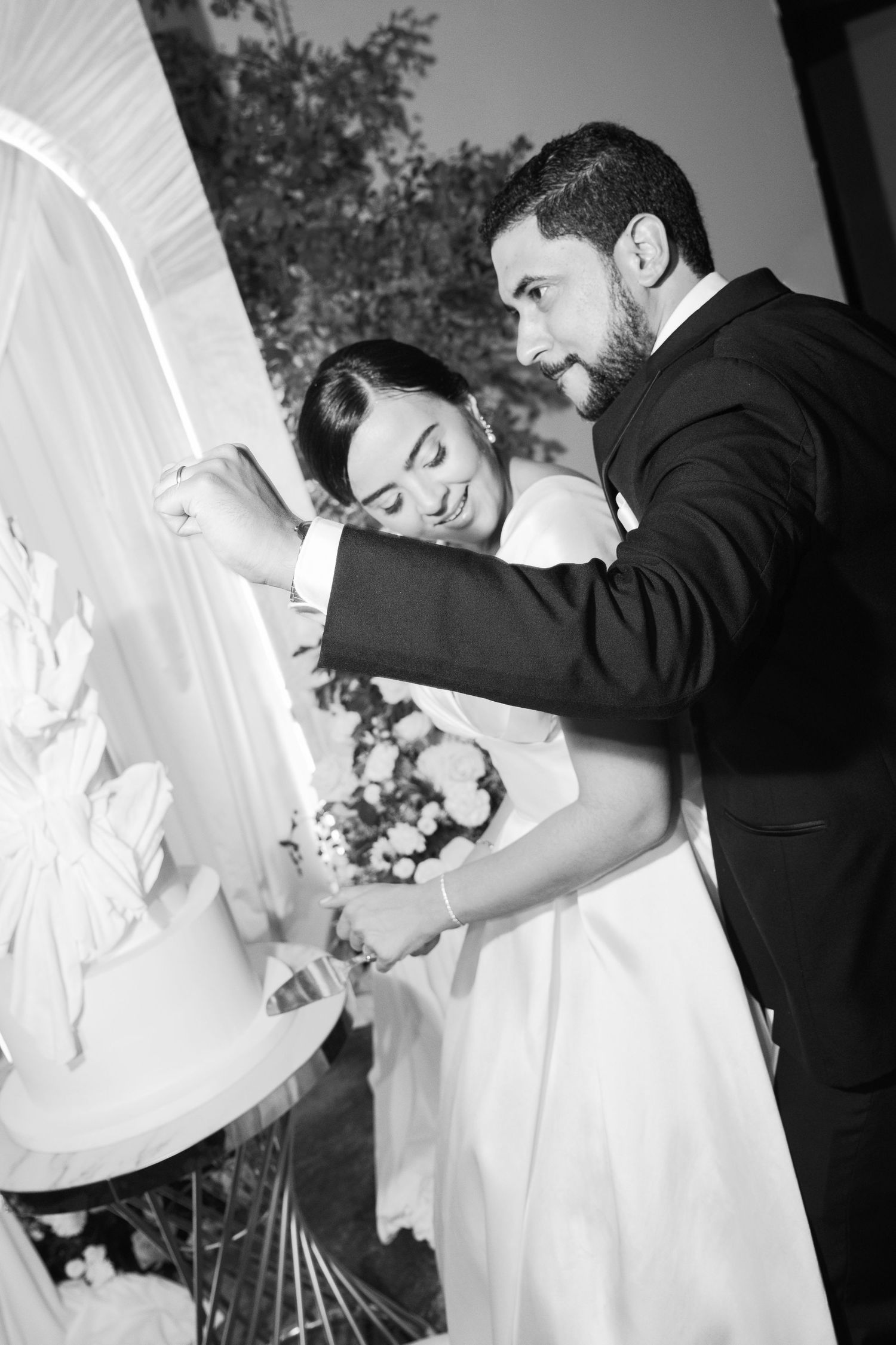 Black and white wedding photo series showing tender moments between newlyweds embracing and dancing together.