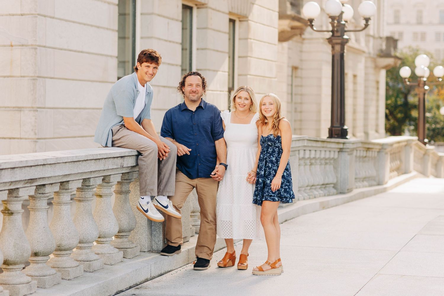 Family portrait session on elegant white stone steps with classic architecture.