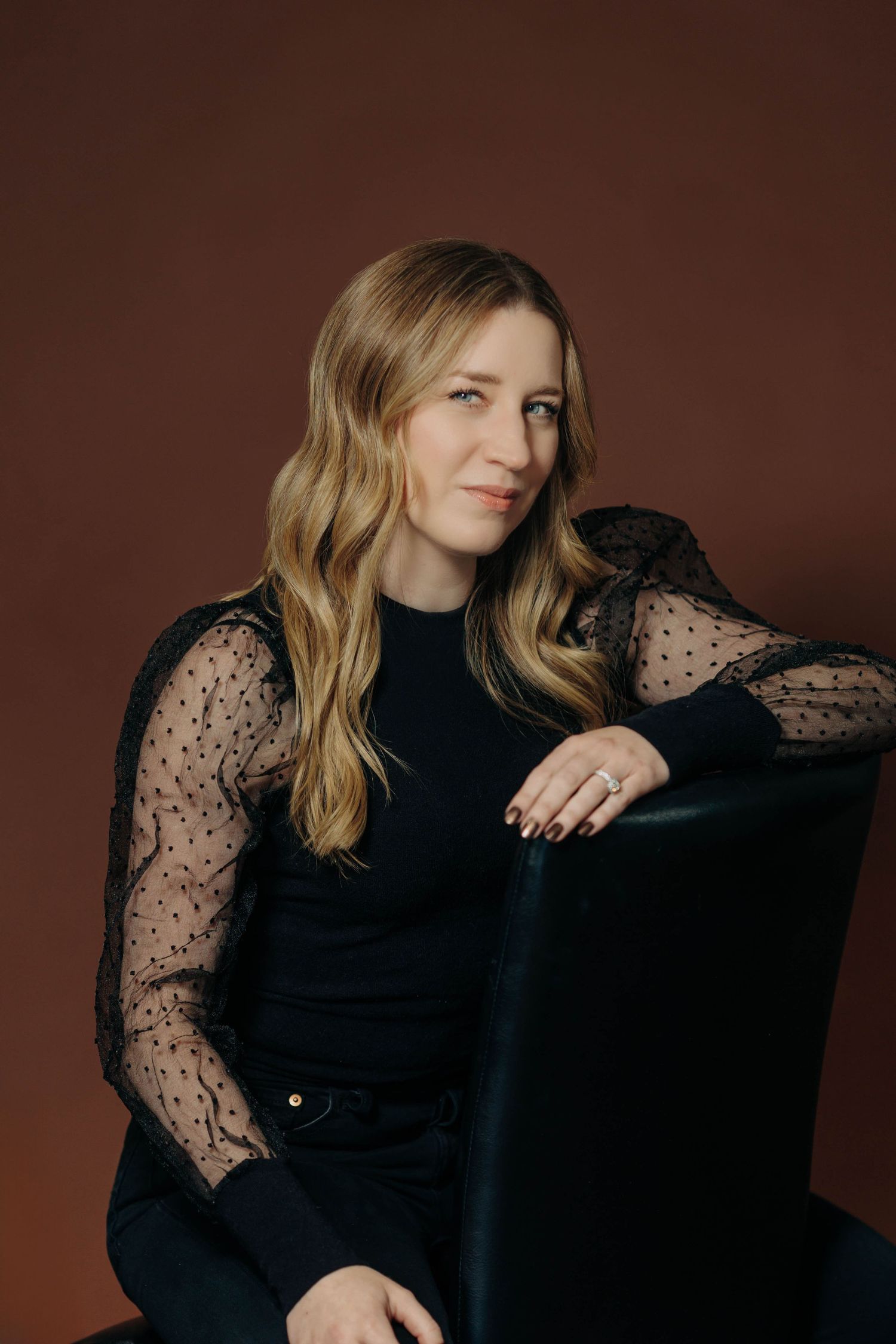 Fashion portraits featuring black lace sleeve details against brown backdrop.