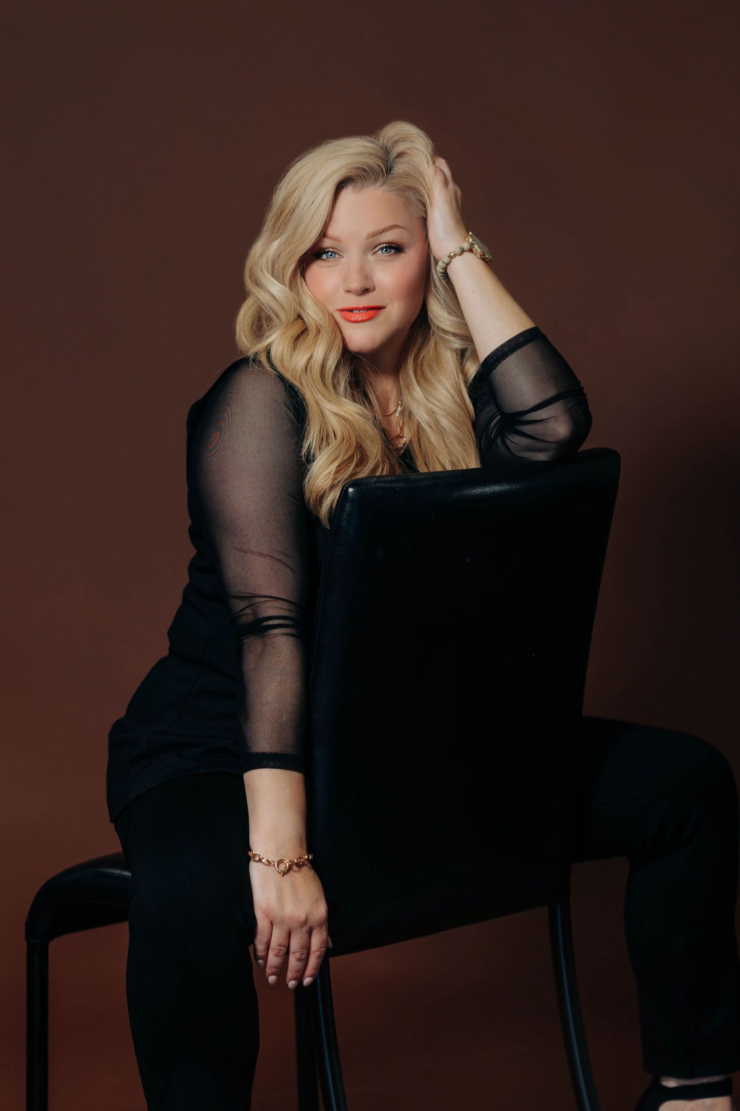 Professional studio portraits showing elegant poses in black attire against dark brown backdrop.