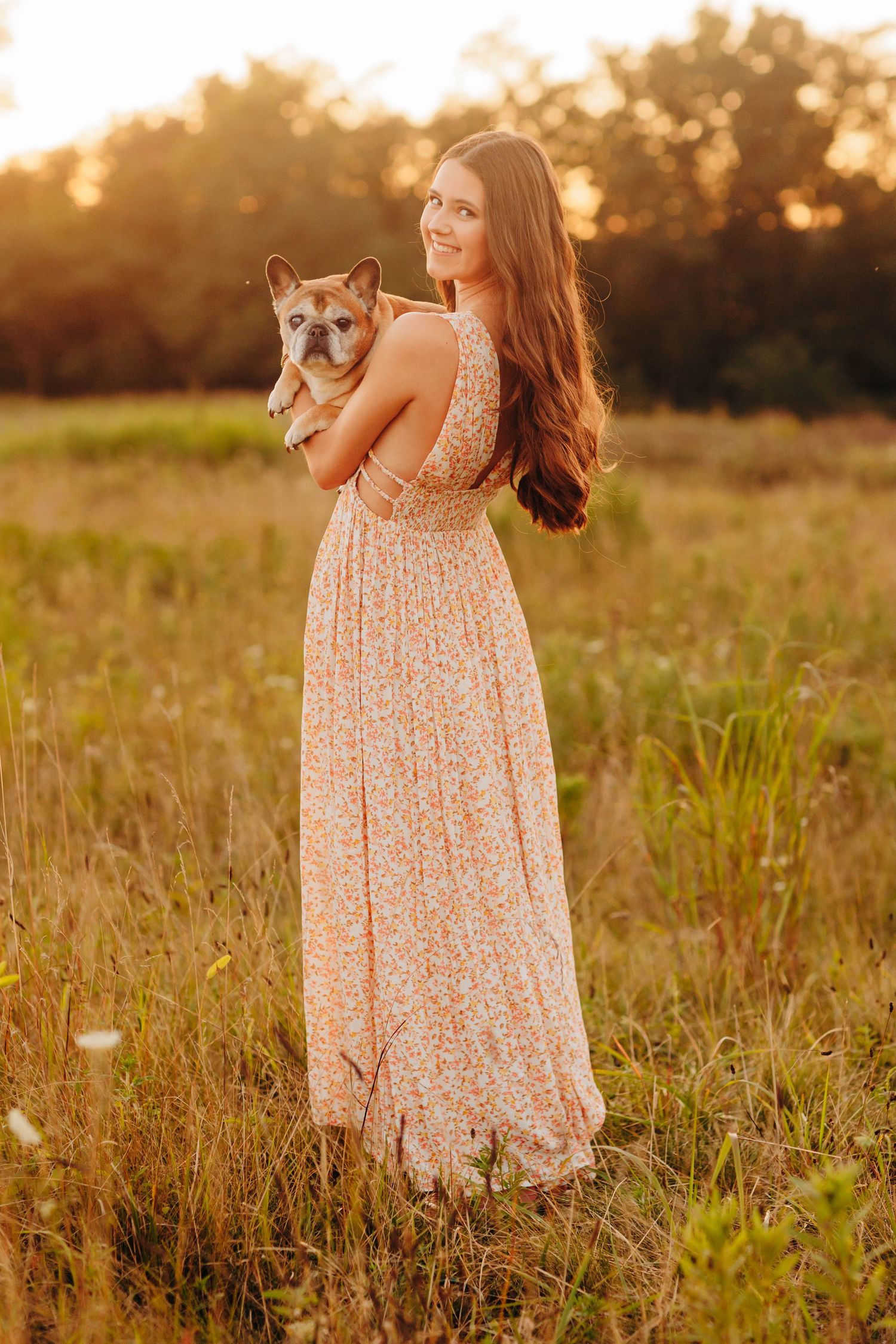 A floral maxi dress and shiba inu dog pose together in a golden sunset field.