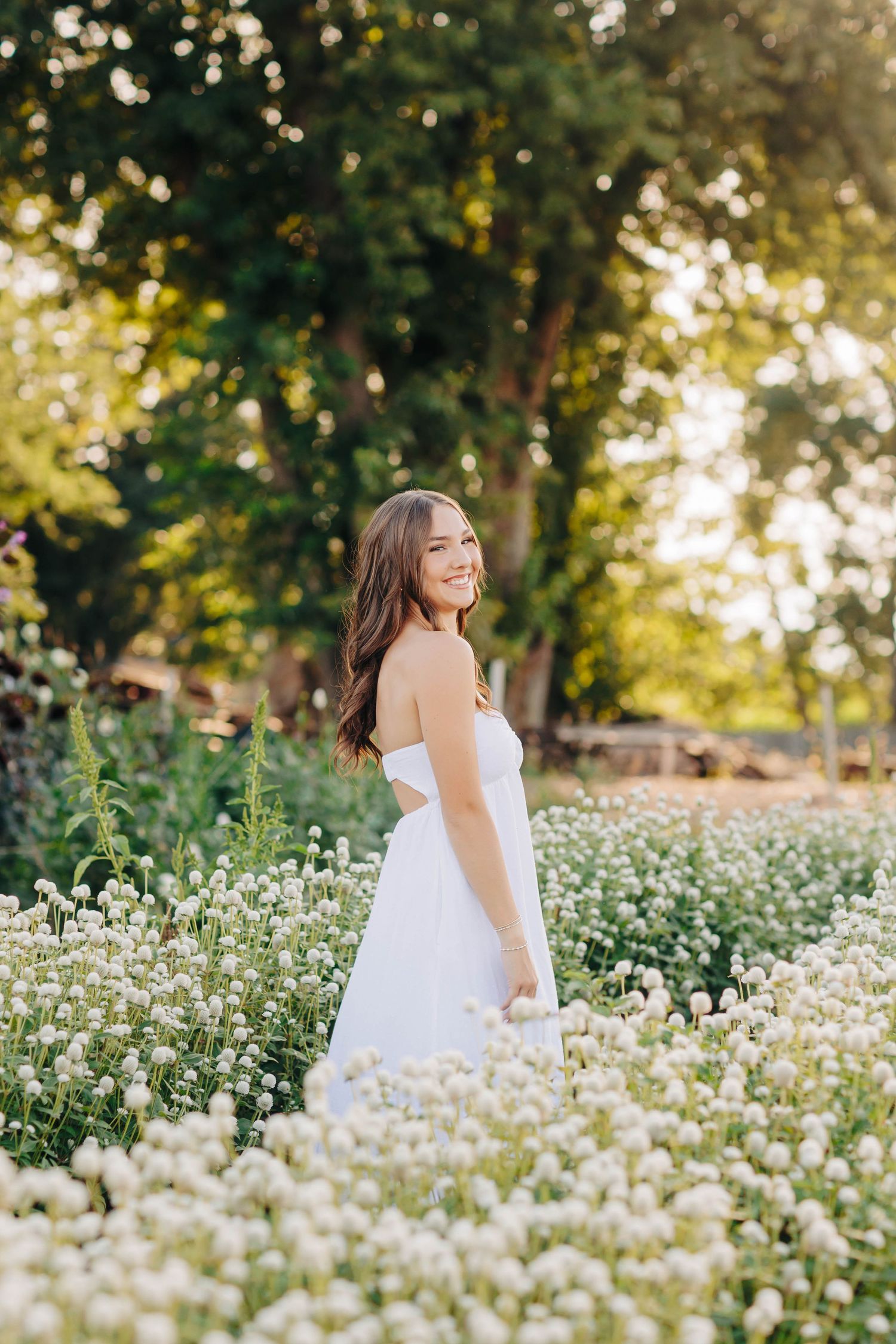 Dancing through a field of white wildflowers in a summer dress.