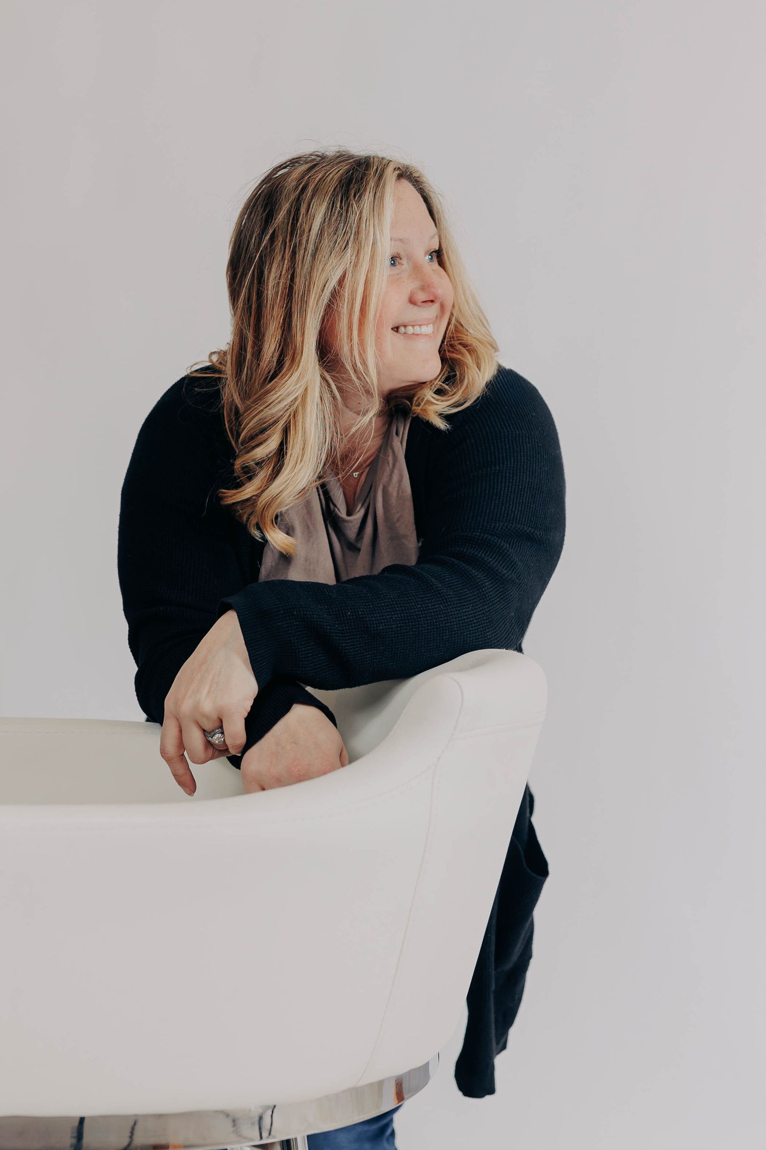 Casual lifestyle portrait against white wall with natural expression.