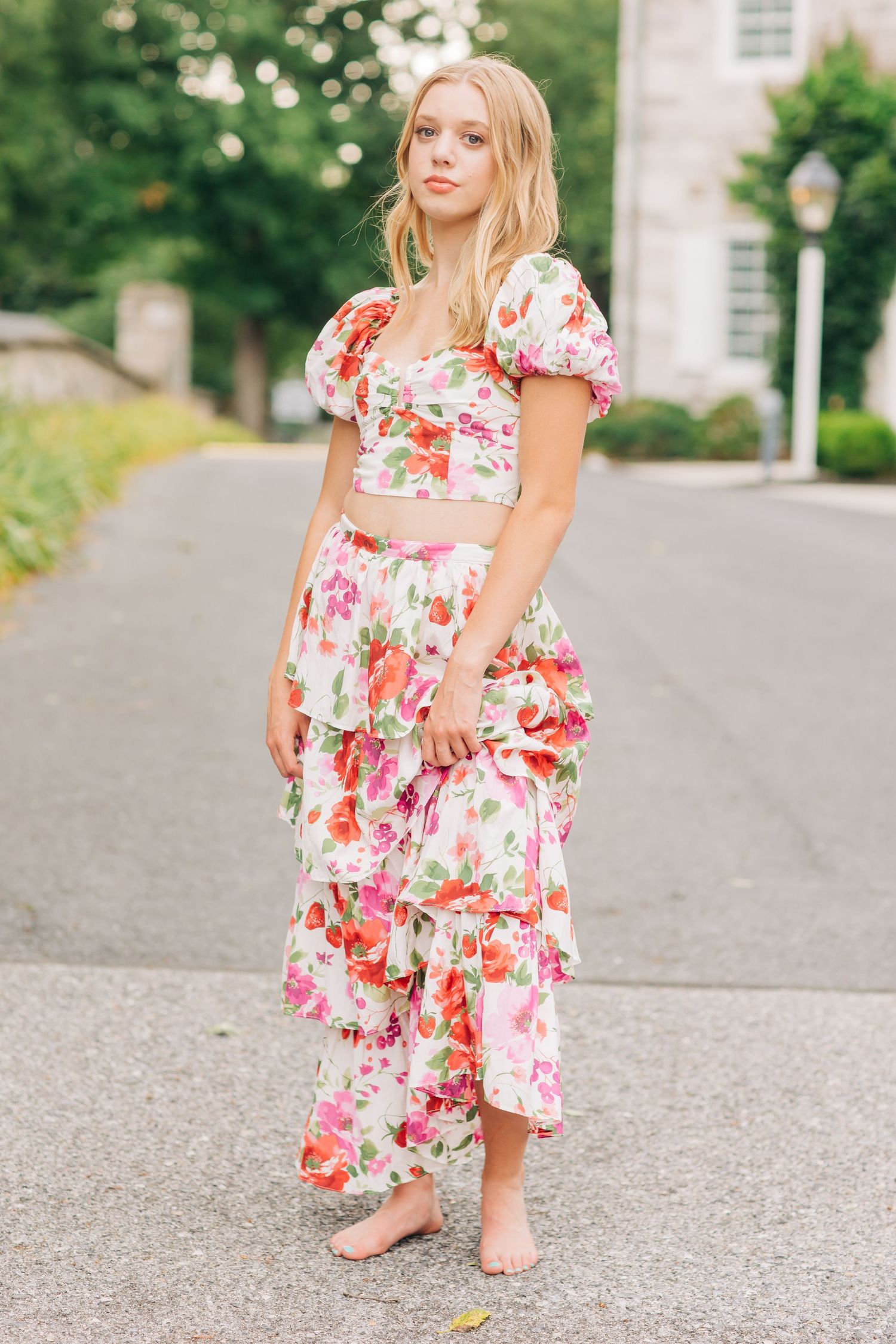 Someone wearing a floral summer dress twirling on a sunny street.