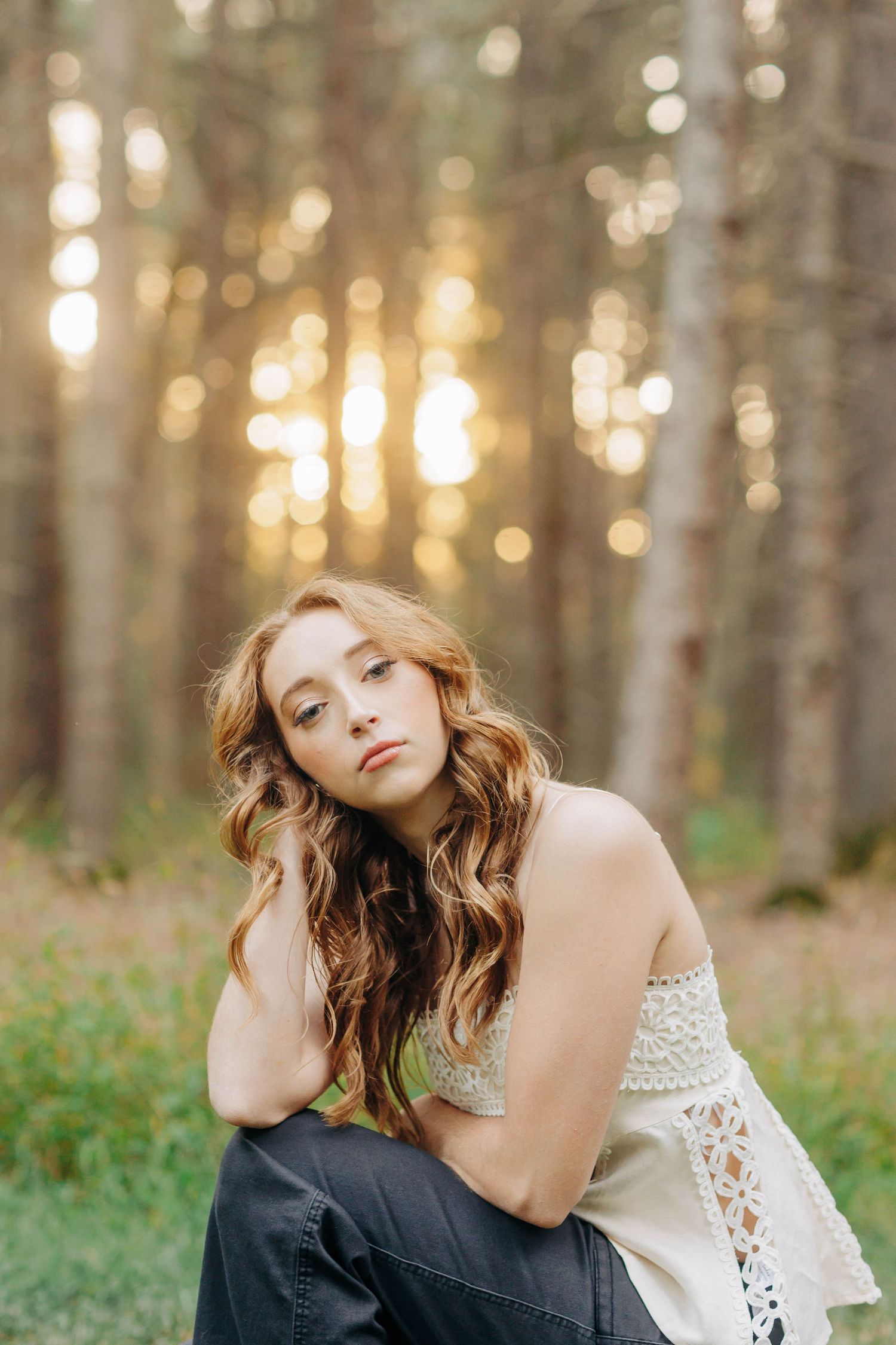Dreamy forest portrait with sunlit trees and white lace details.