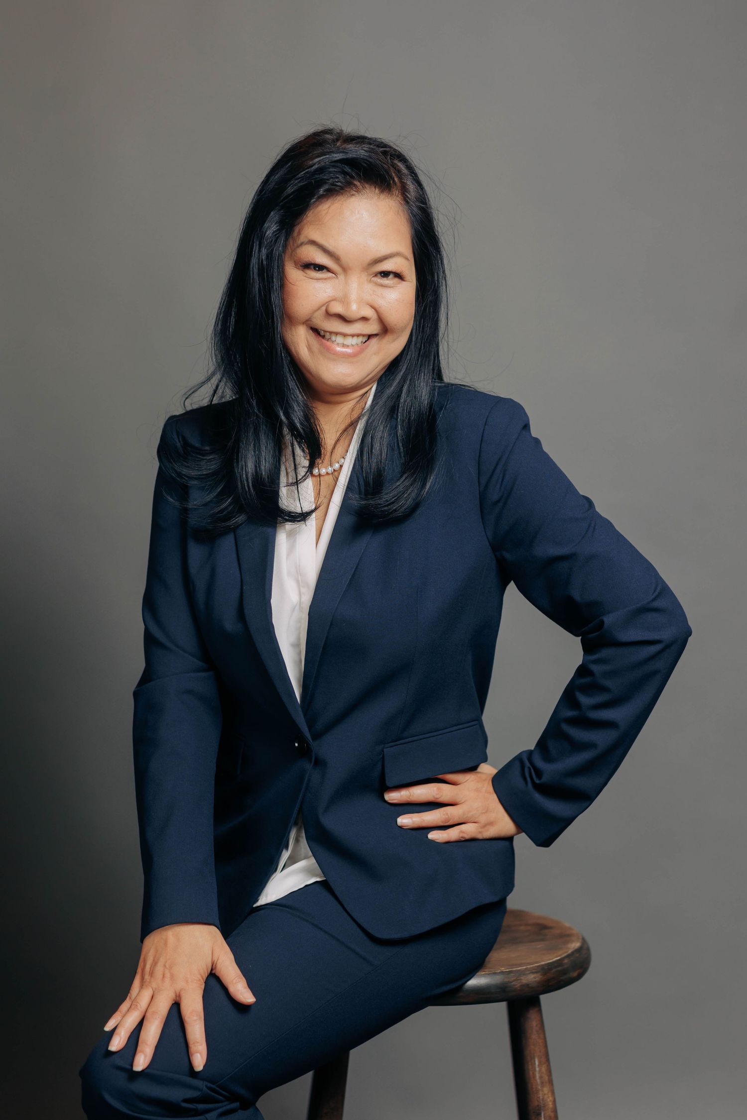 Business portrait series in navy suit showing dynamic poses against grey backdrop.