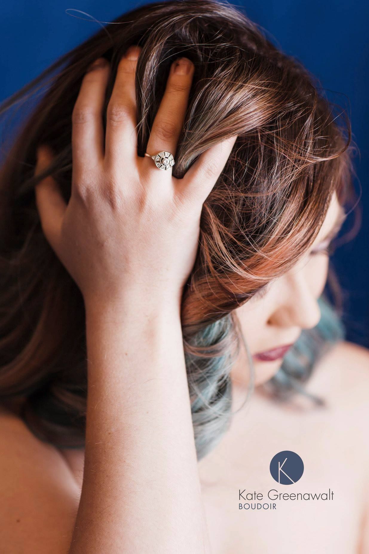 Close-up portrait showing hand in hair against deep blue background with studio lighting.