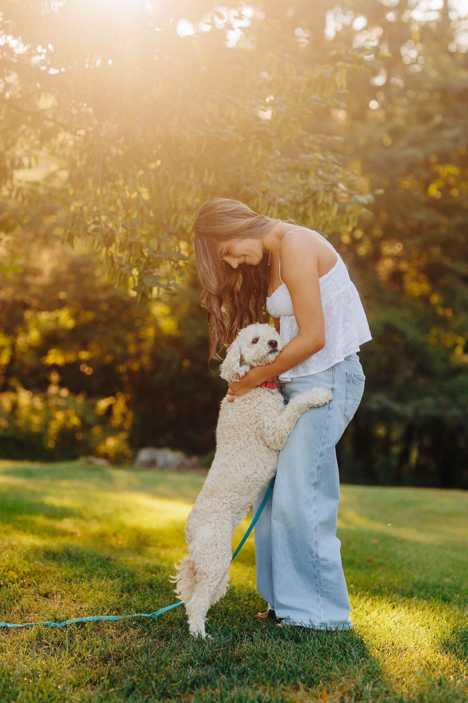 Playing with a small white dog in a sunny garden setting.