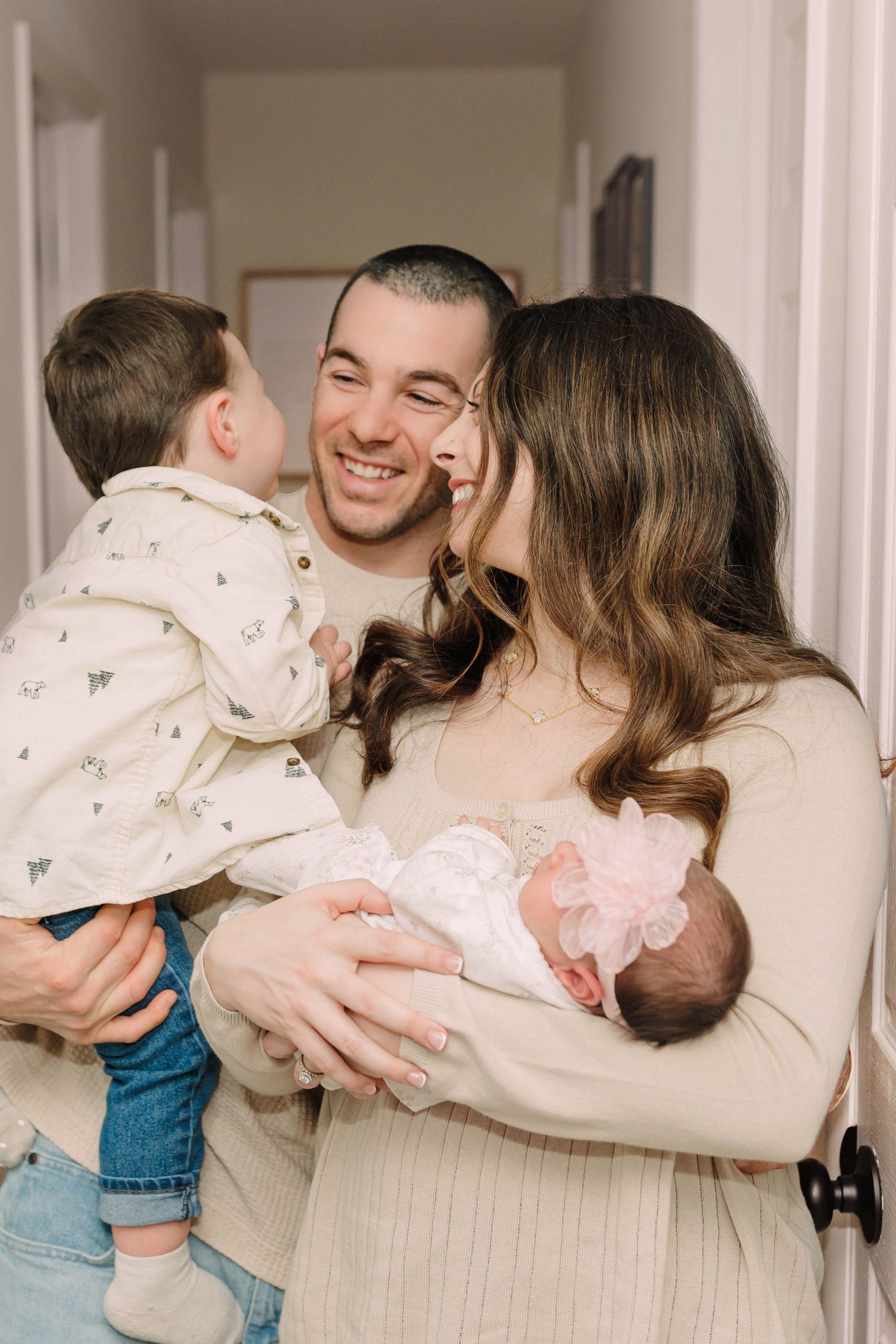 Sweet family moment with siblings meeting their new baby sibling at home.