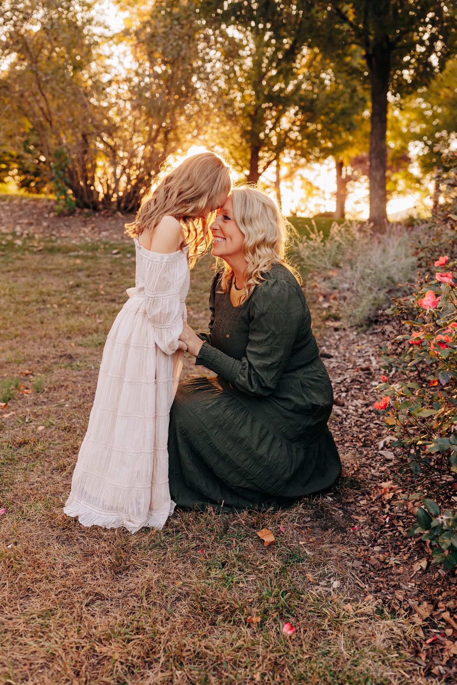 Tender outdoor moment between two people in autumn setting with fallen leaves.