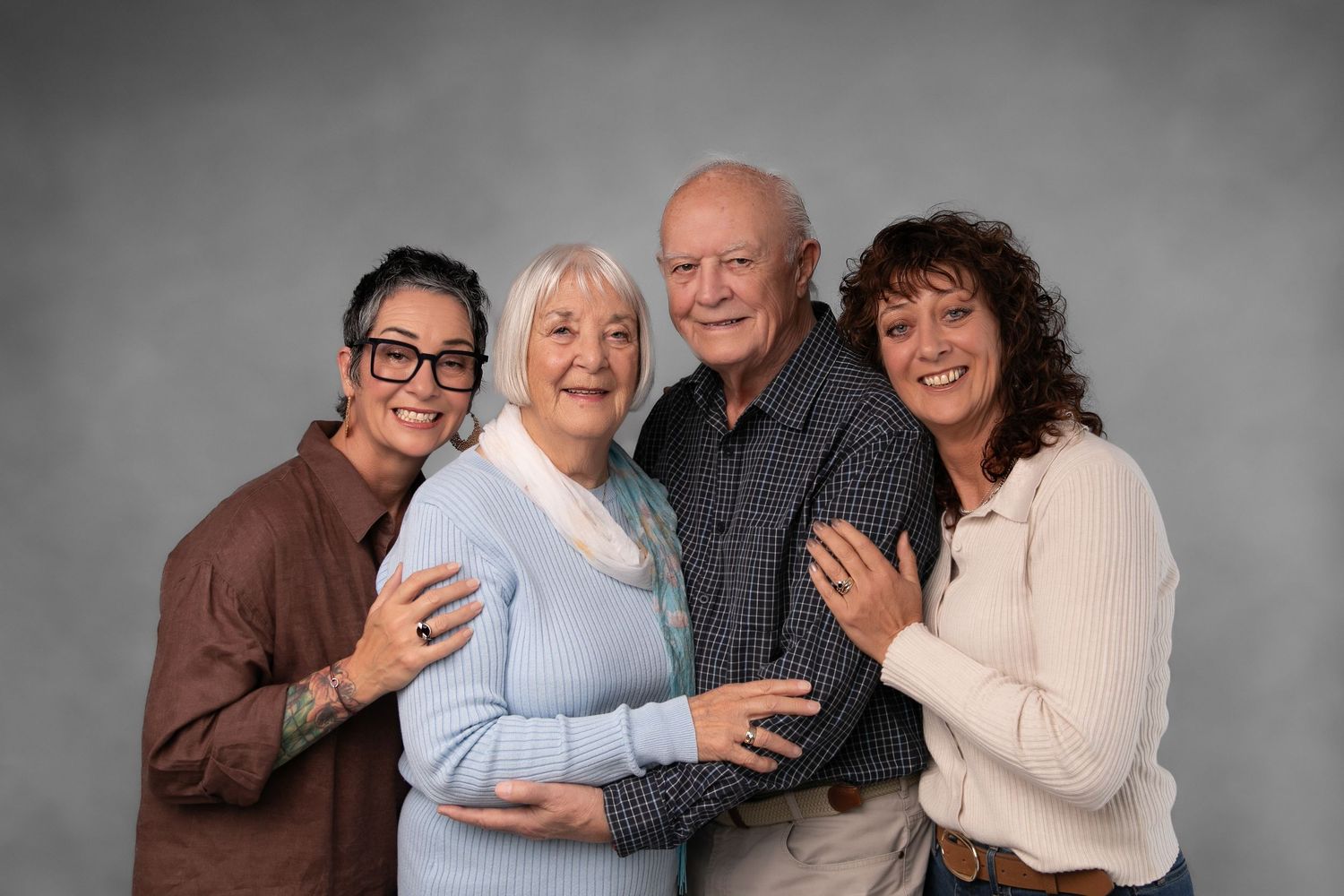 A group of people laughing and embracing in a black and white photo collage.