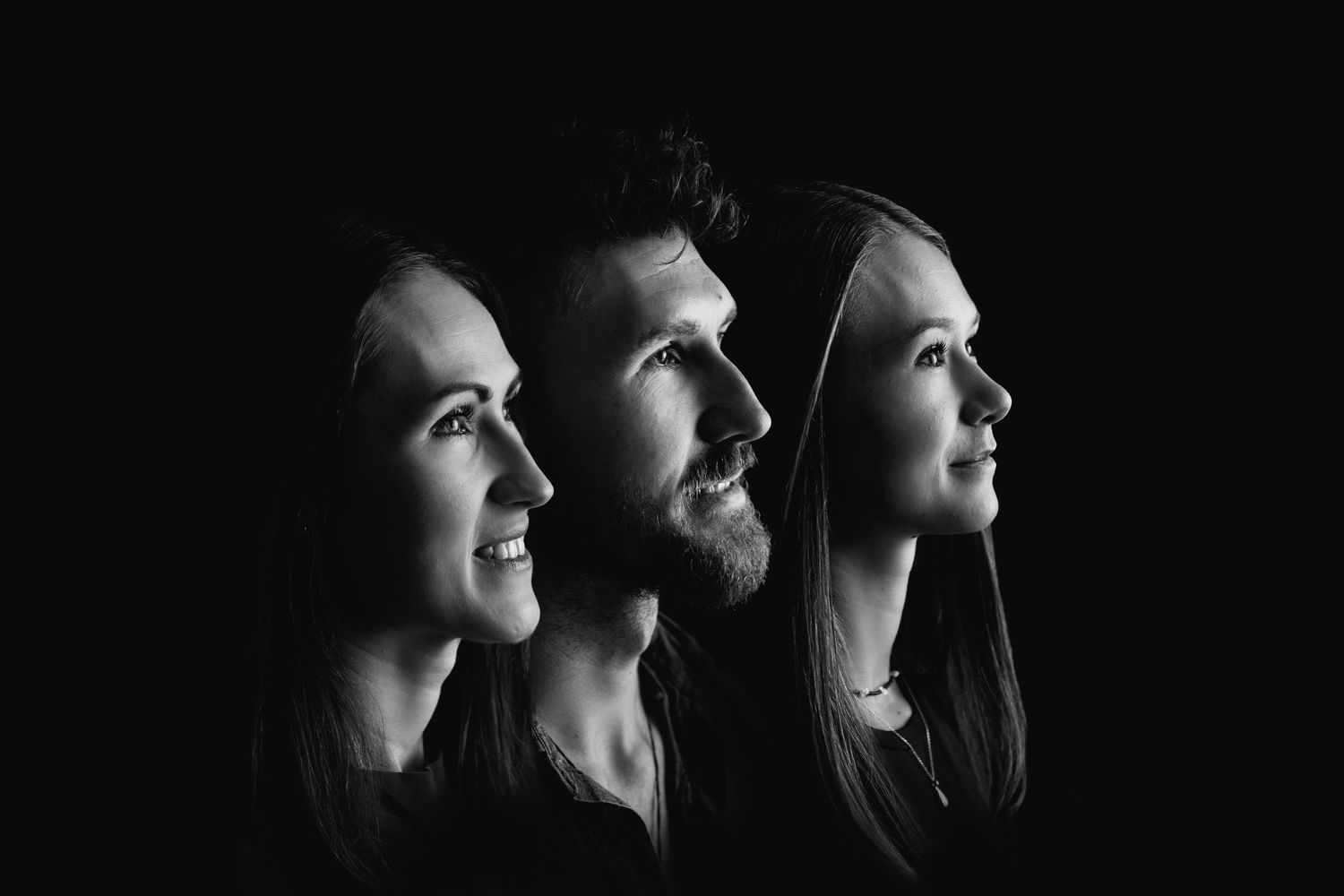 Black and white profile portraits arranged in a row showing people looking upward with dramatic lighting and expressions.
