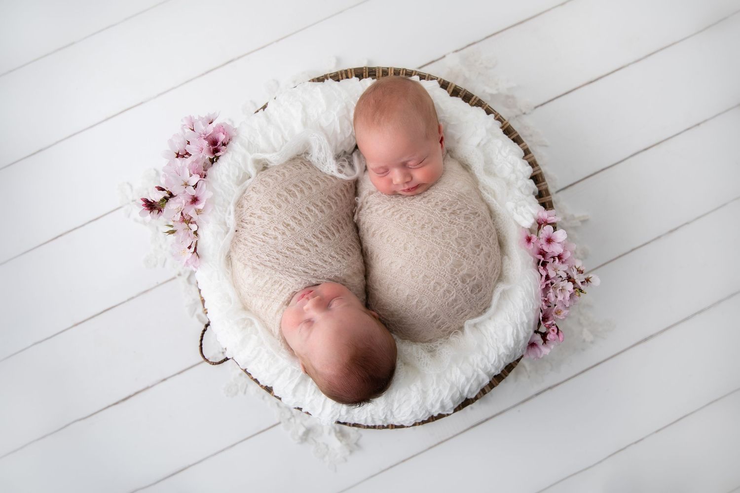 Newborn photography collage showing baby sleeping in white baskets against light wooden floor background.