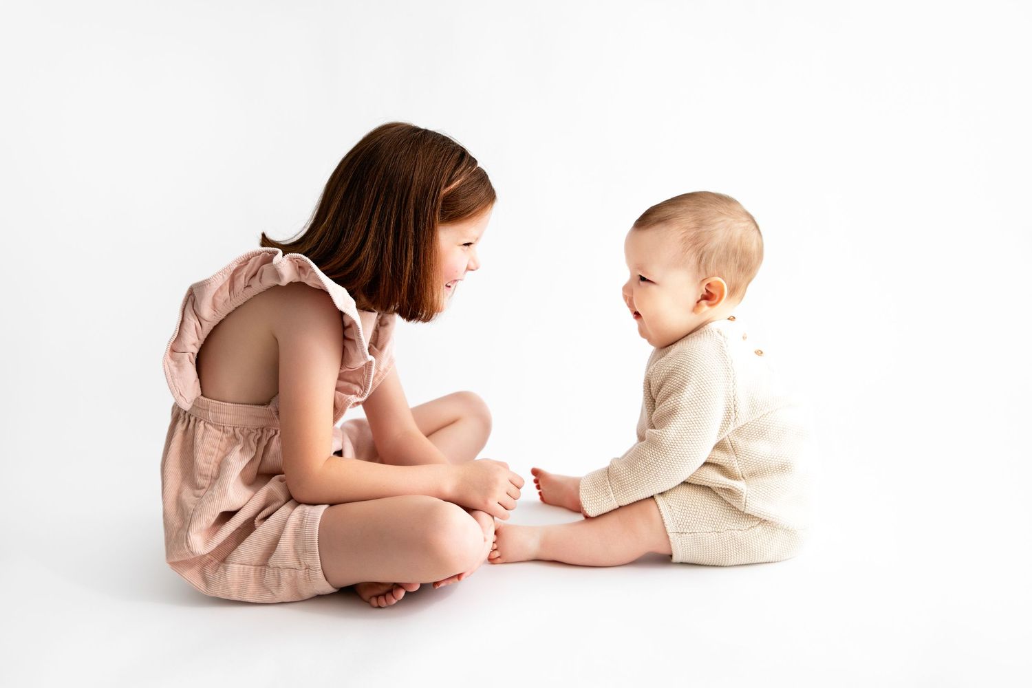 A series of photos showing a parent and baby sitting together in soft pink tones against a white background.