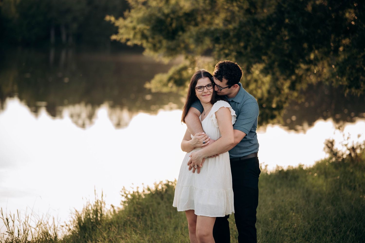 A couple shares tender moments during their engagement session by a peaceful lake.
