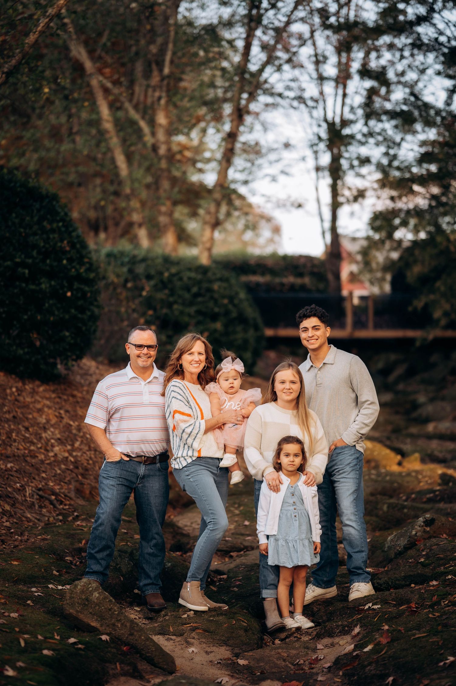 Family sitting together on rustic stone steps during an outdoor photo session.