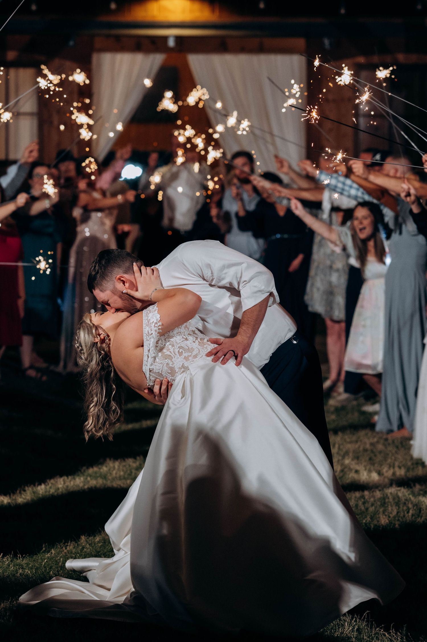 Dramatic nighttime wedding dance with twinkle lights in the background.