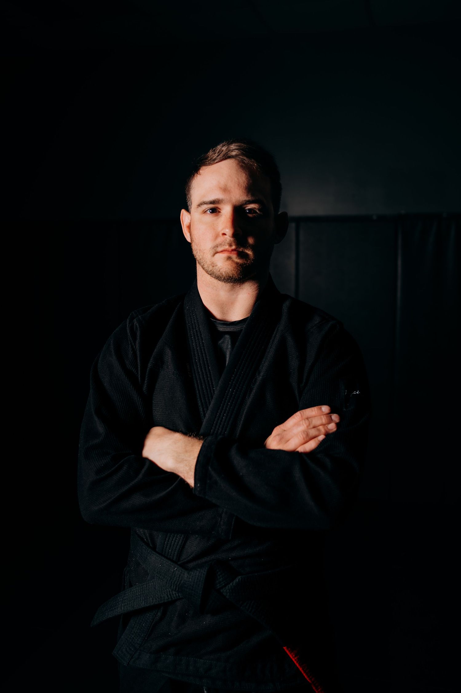 Low-key portrait series showing person in black martial arts uniform against dark background.