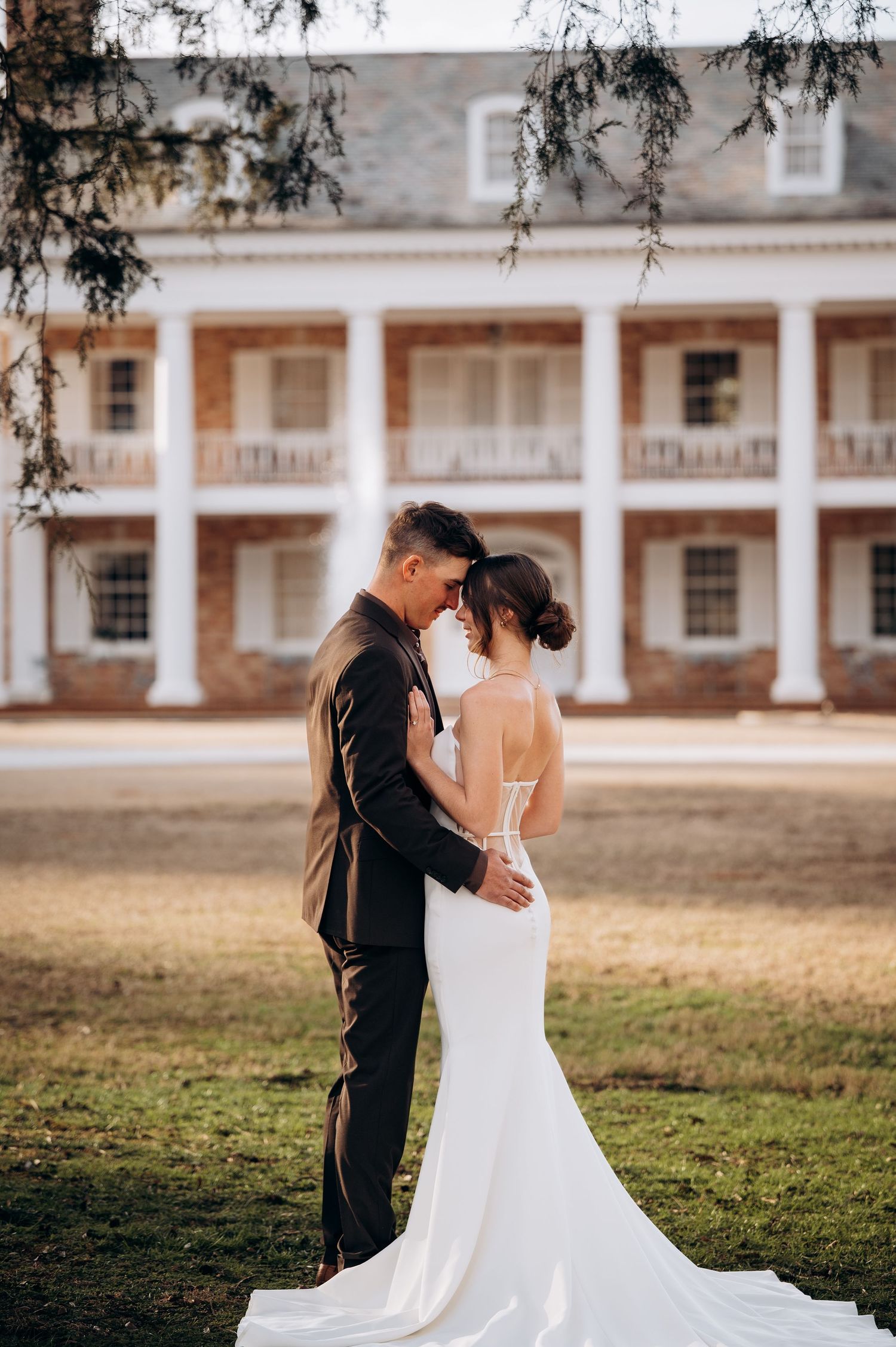 A romantic moment captured against a historic colonial building with white columns.