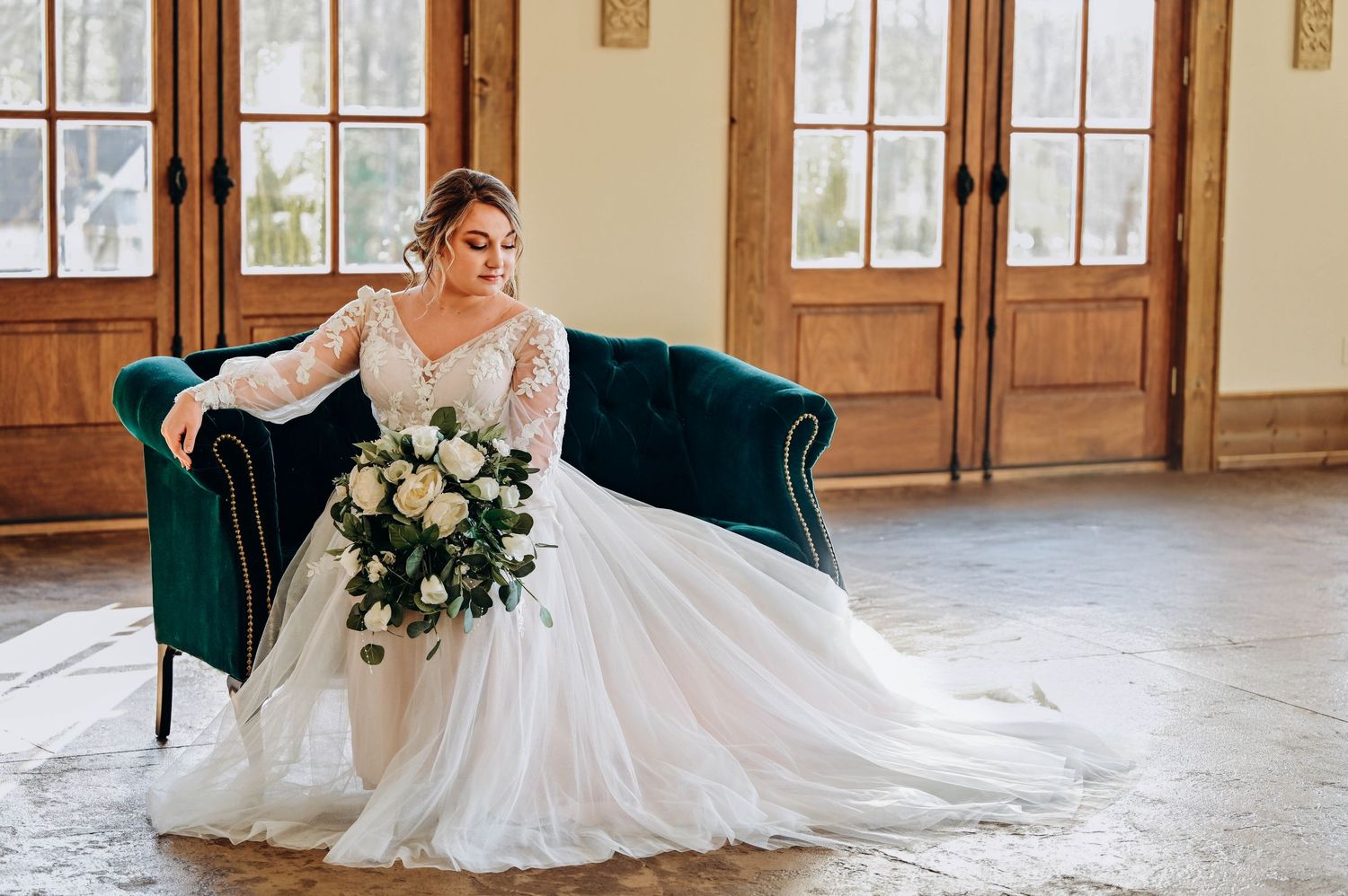 Wedding dress with intricate lace details spread beautifully across vintage hardwood floor.