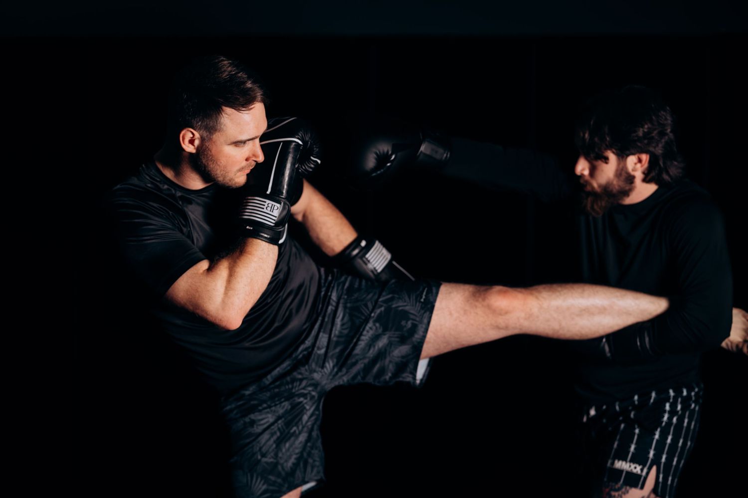 Action sequence showing martial arts training moves in dark studio setting.