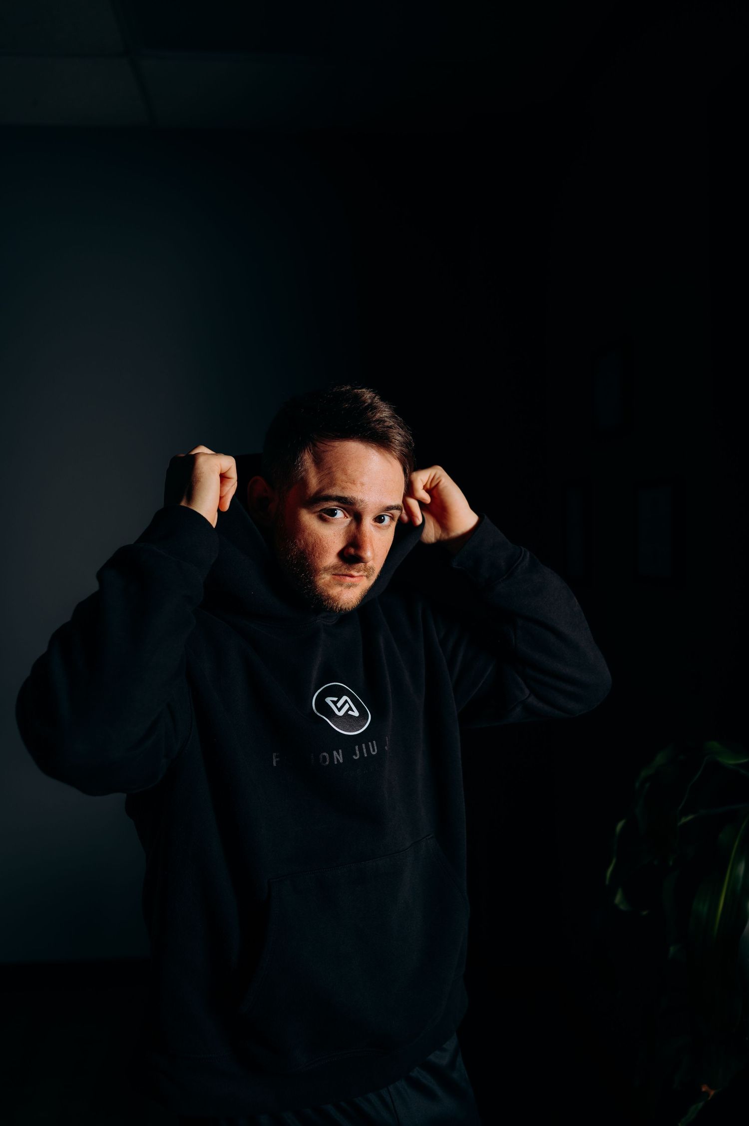 Athletic person in black hoodie demonstrating different poses in dramatic lighting.