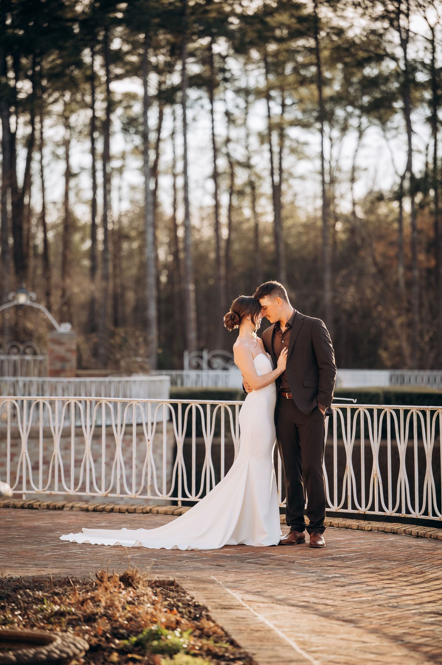 Bride and groom sharing an intimate moment on a terrace with white iron railings.