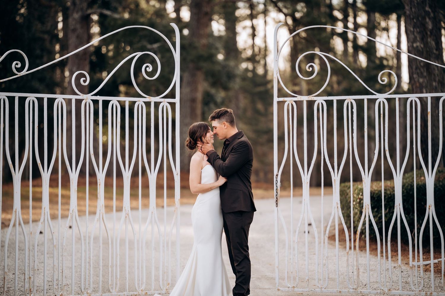 Romantic wedding photos captured along a decorative white iron fence.