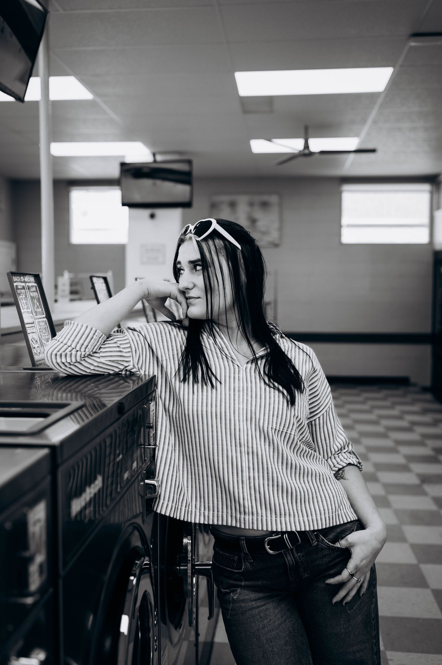 Black and white photo series showing a person in a striped shirt posing against a checkered floor interior.