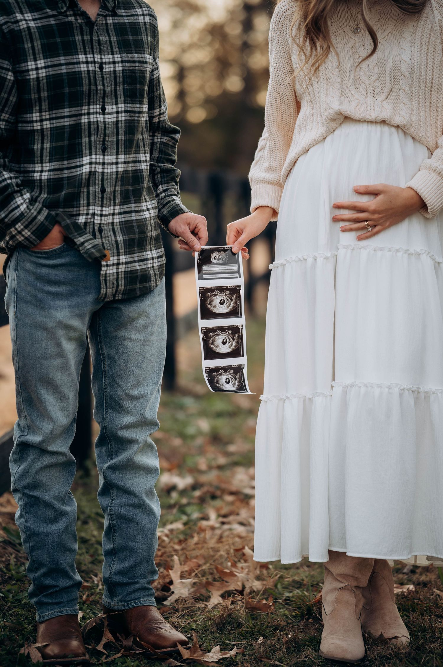 A close-up shot showing ultrasound photos and a white dress during a pregnancy announcement.