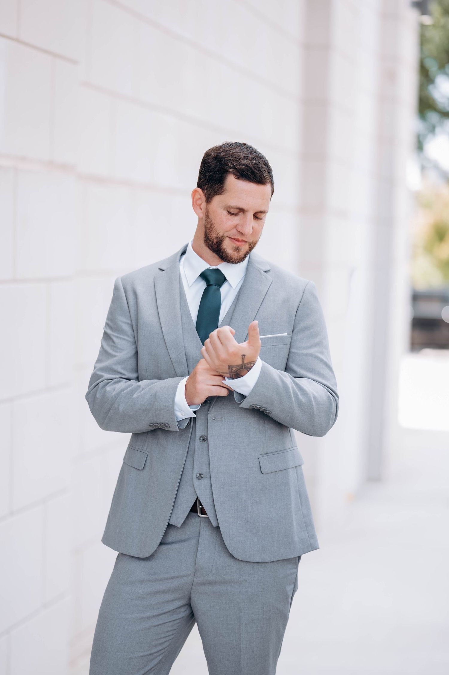 Groom in light gray suit showing emotional reaction during wedding ceremony.