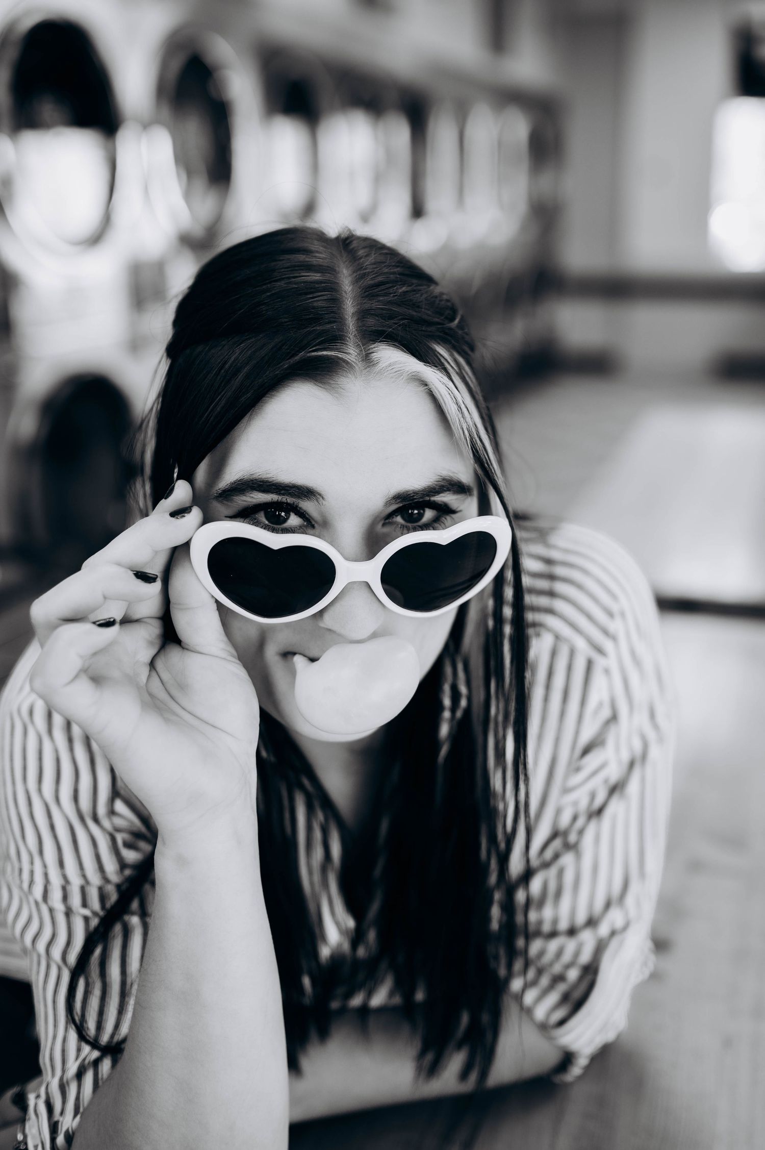 Black and white photo sequence showing a person in striped top and white sunglasses resting on wooden table.
