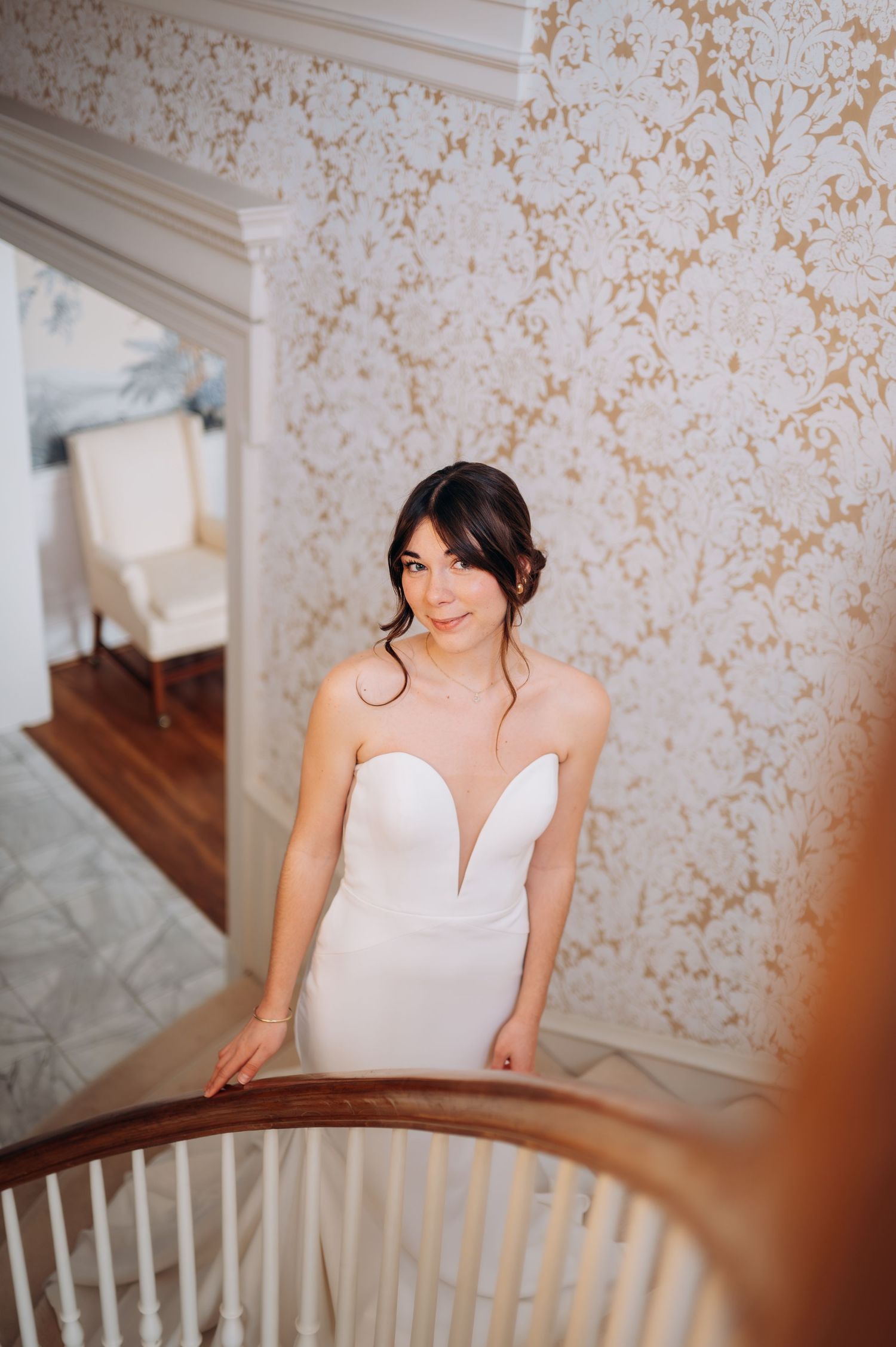 Elegant bridal portrait series showing details of white wedding dress near wooden banister.