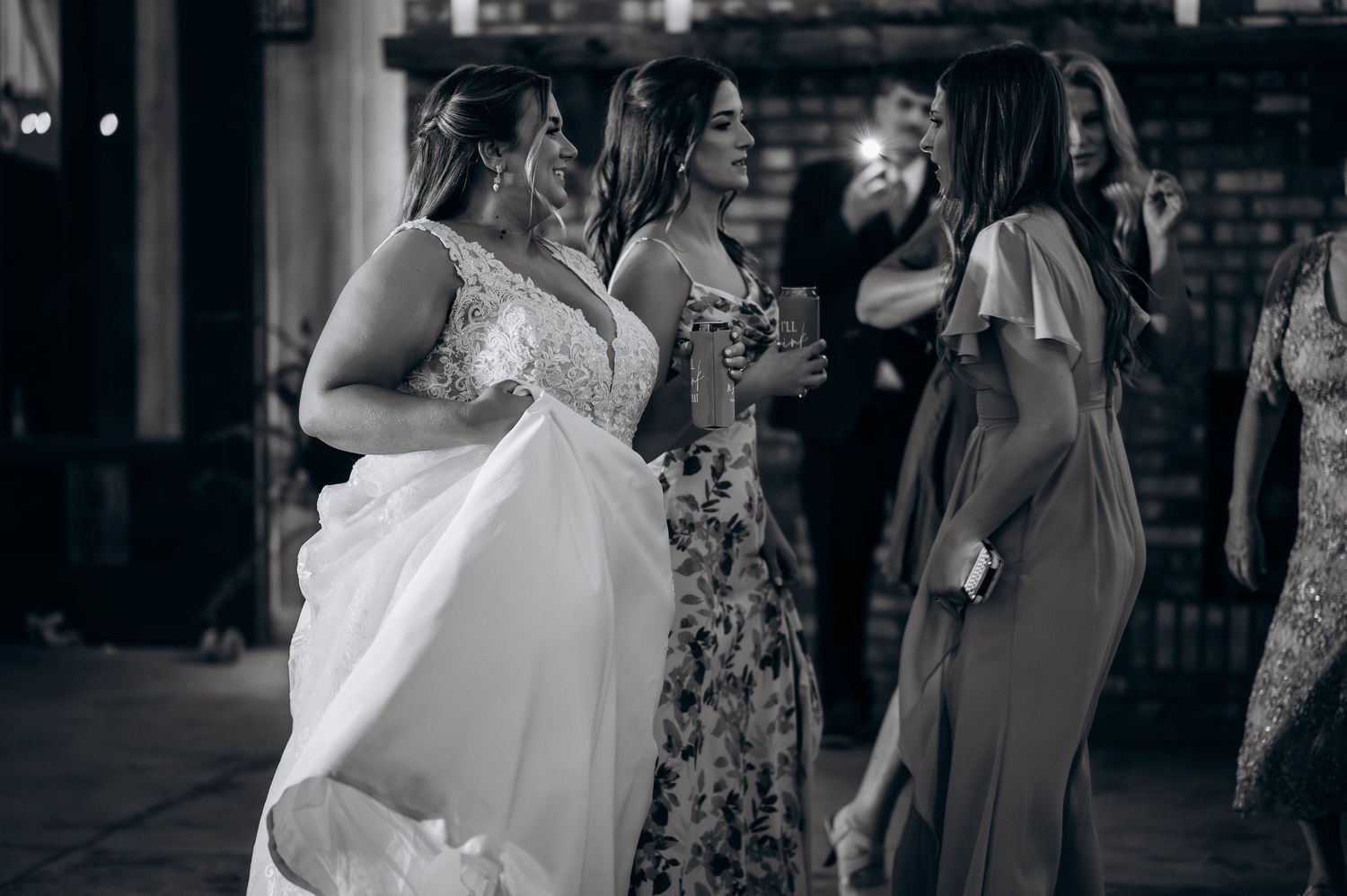 Black and white photo of wedding reception with guests mingling.