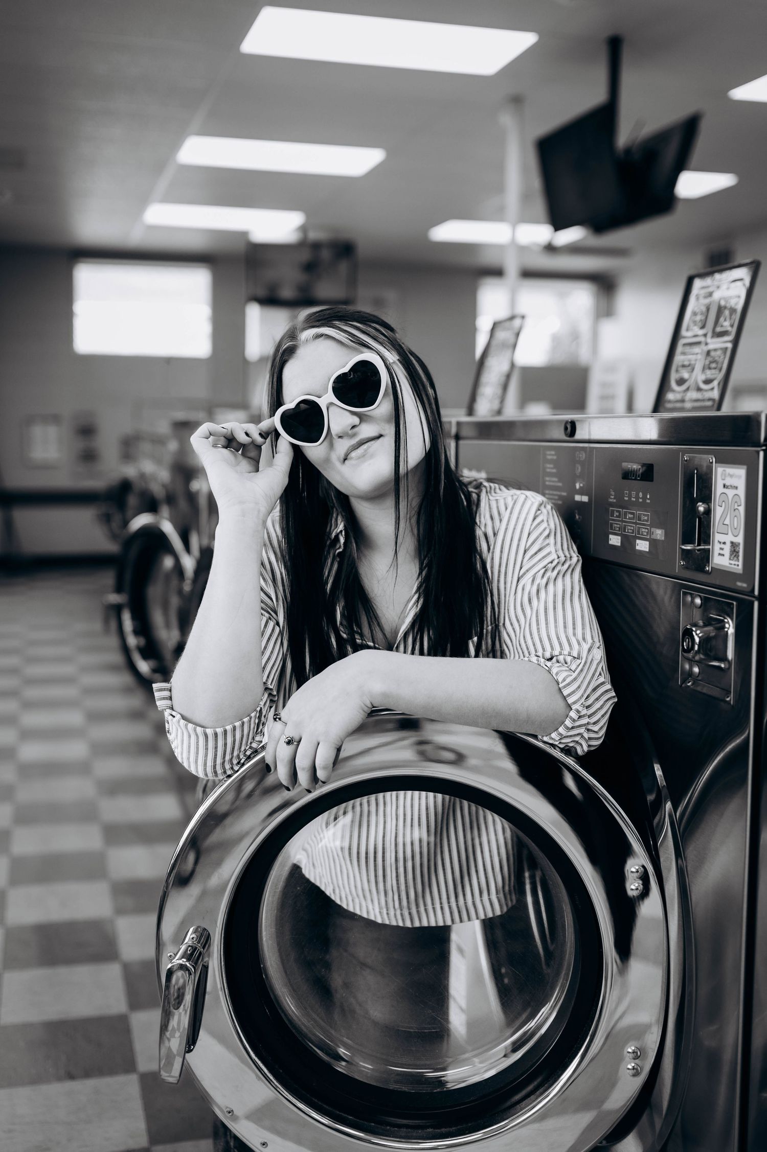 Black and white photo sequence of someone looking through a washing machine door window at a laundromat.