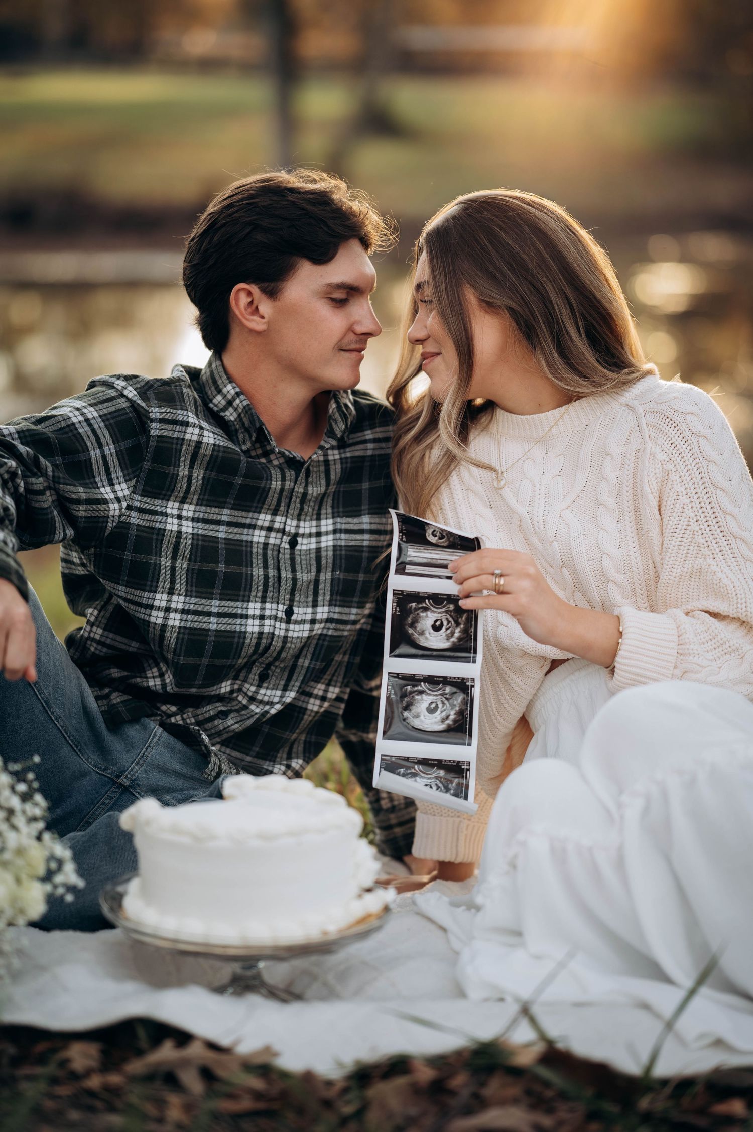 Couple holding ultrasound photos during pregnancy announcement photoshoot.