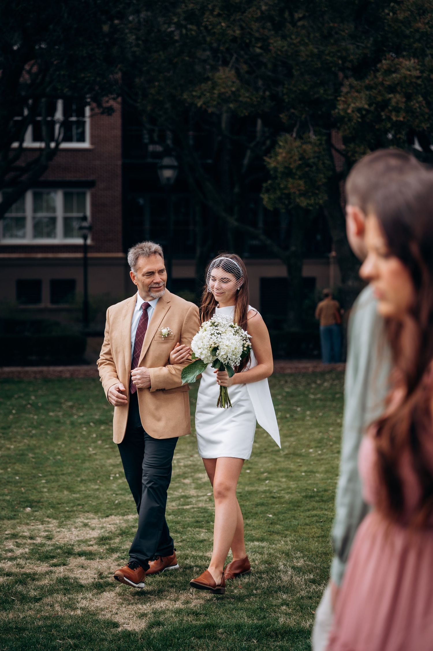 A couple shares tender moments on a grassy lawn during an autumn photoshoot.