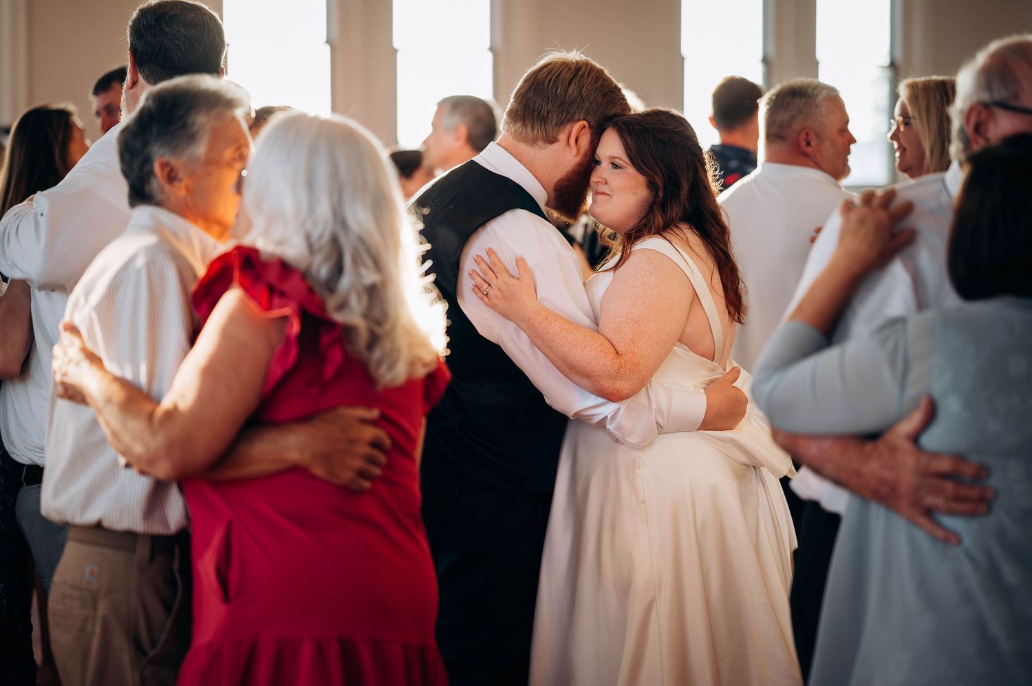 Couples slow dancing together during intimate wedding reception moment.