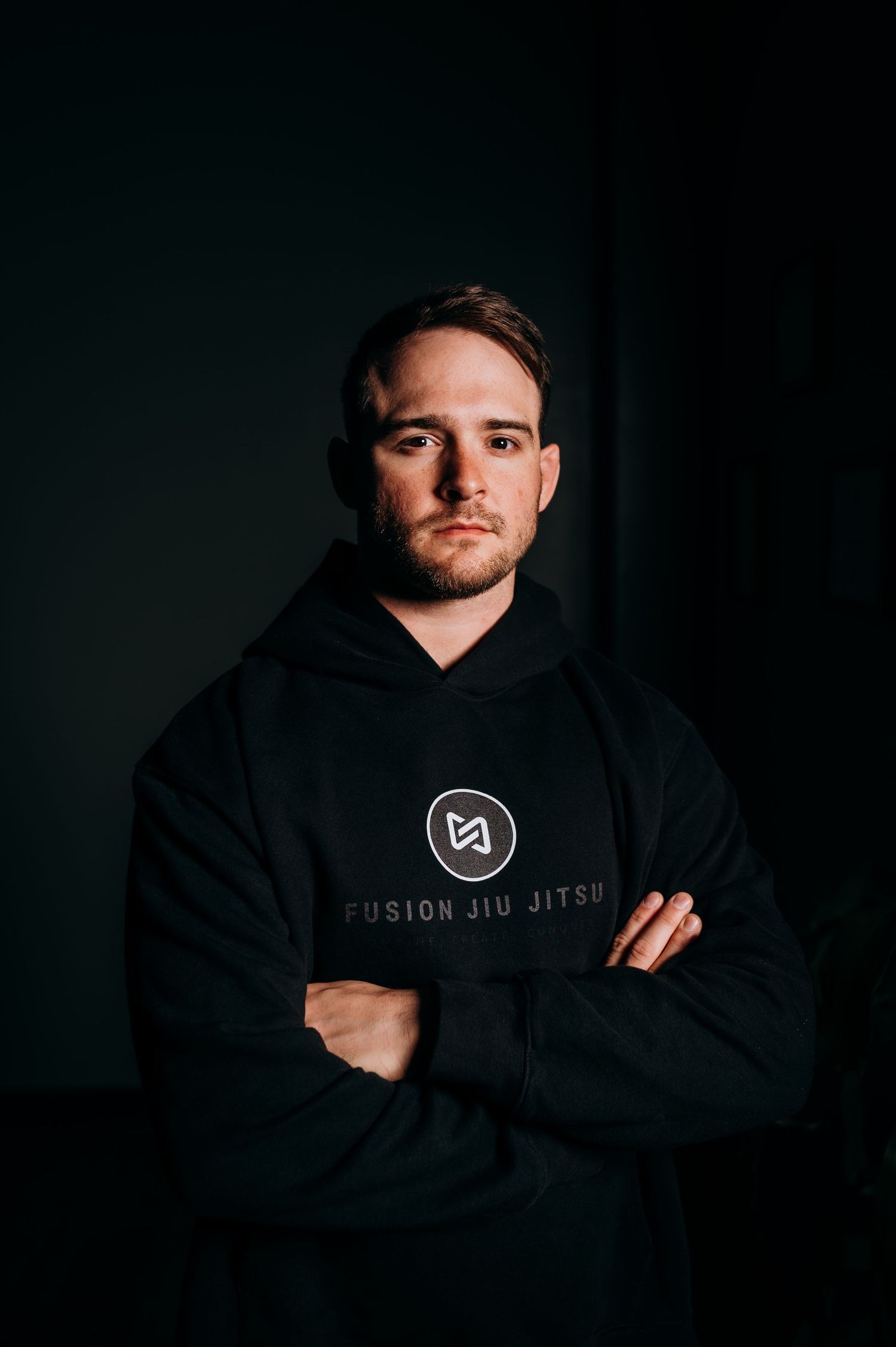 Dark moody portrait series featuring person in black hoodie against shadowy background.