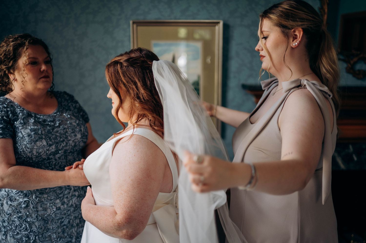 Final wedding preparations with attendants helping the bride get ready.
