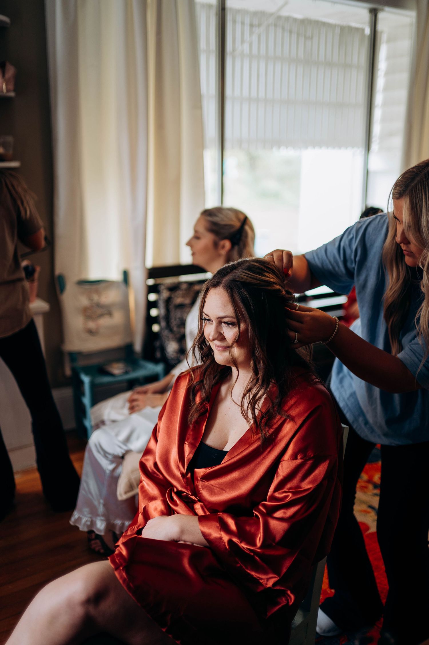 Getting ready scene with someone wearing a silk red robe in morning light.