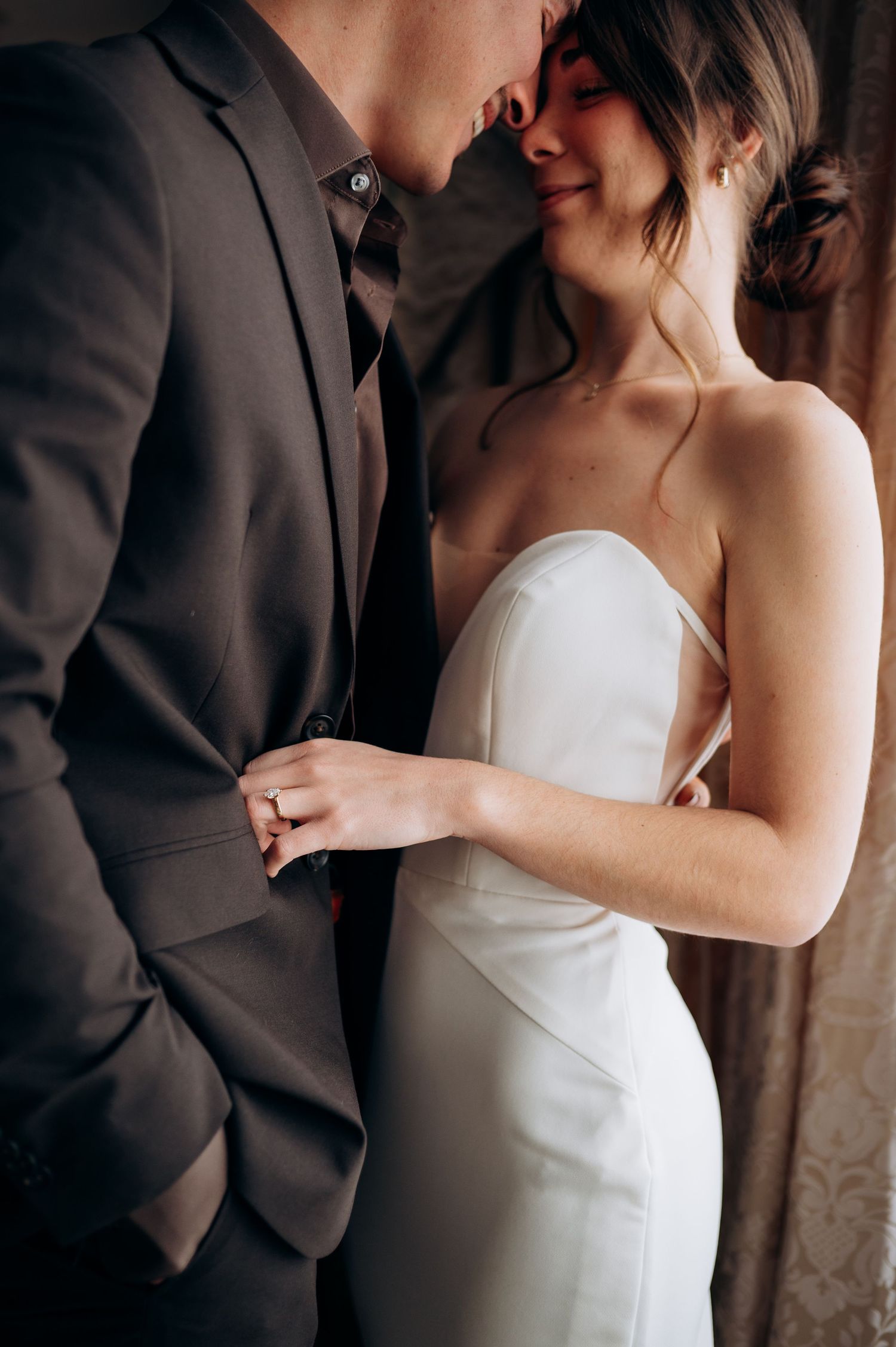 Intimate close-up of couple in wedding attire sharing tender moment.