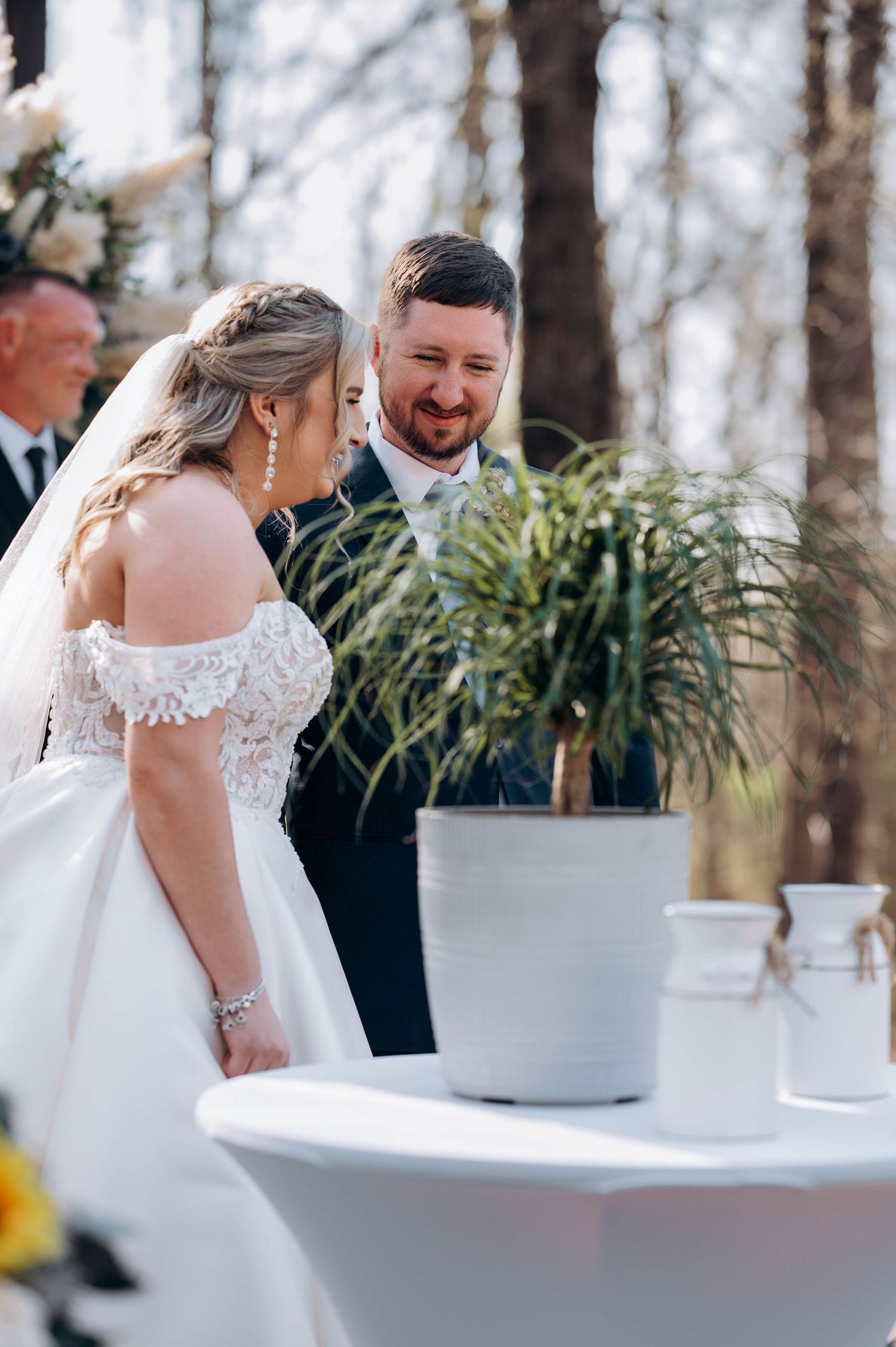 Emotional wedding ceremony moment captured with white floral arrangements and greenery.