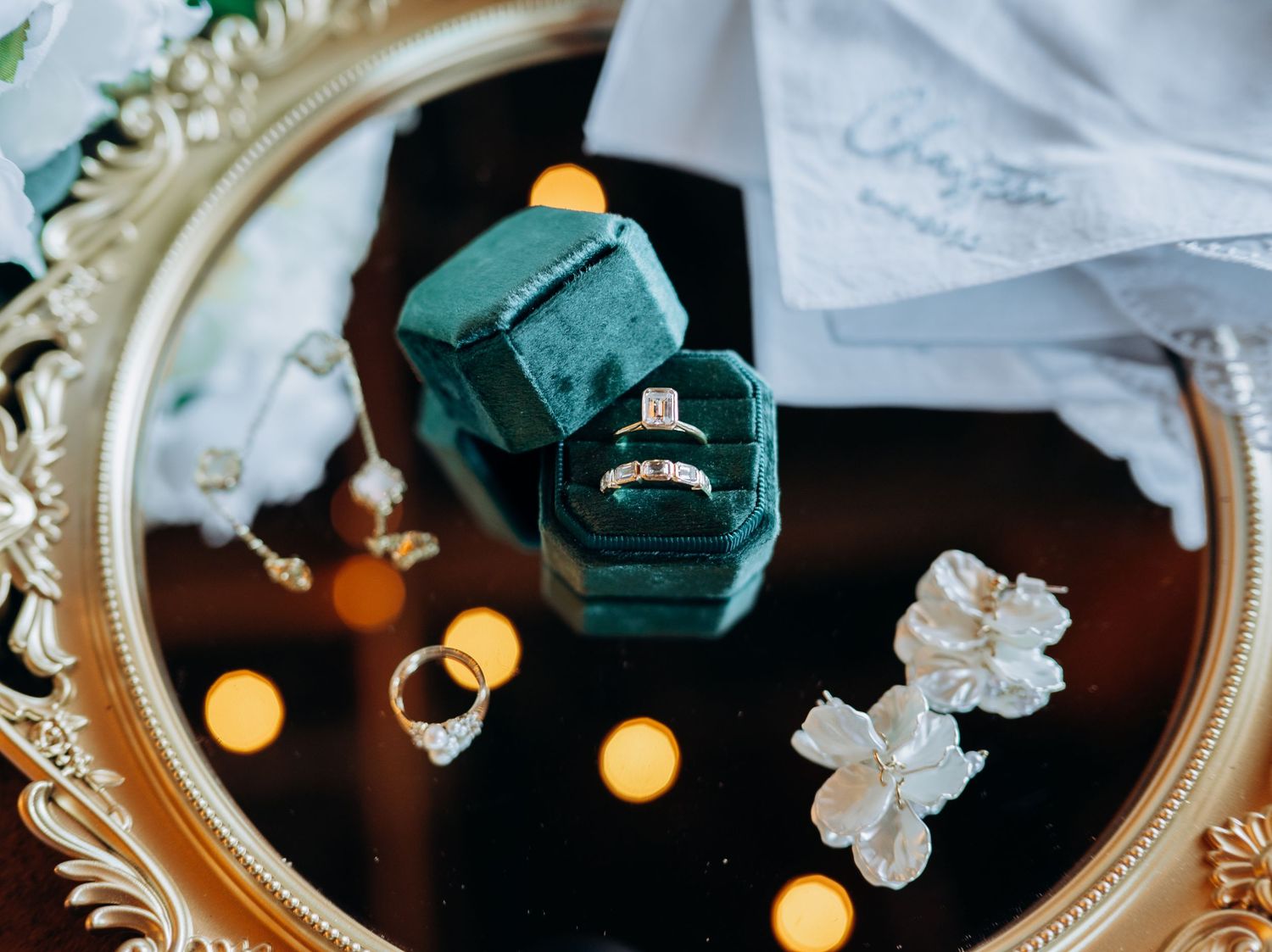 Wedding rings and jewelry displayed on ornate vintage tray.