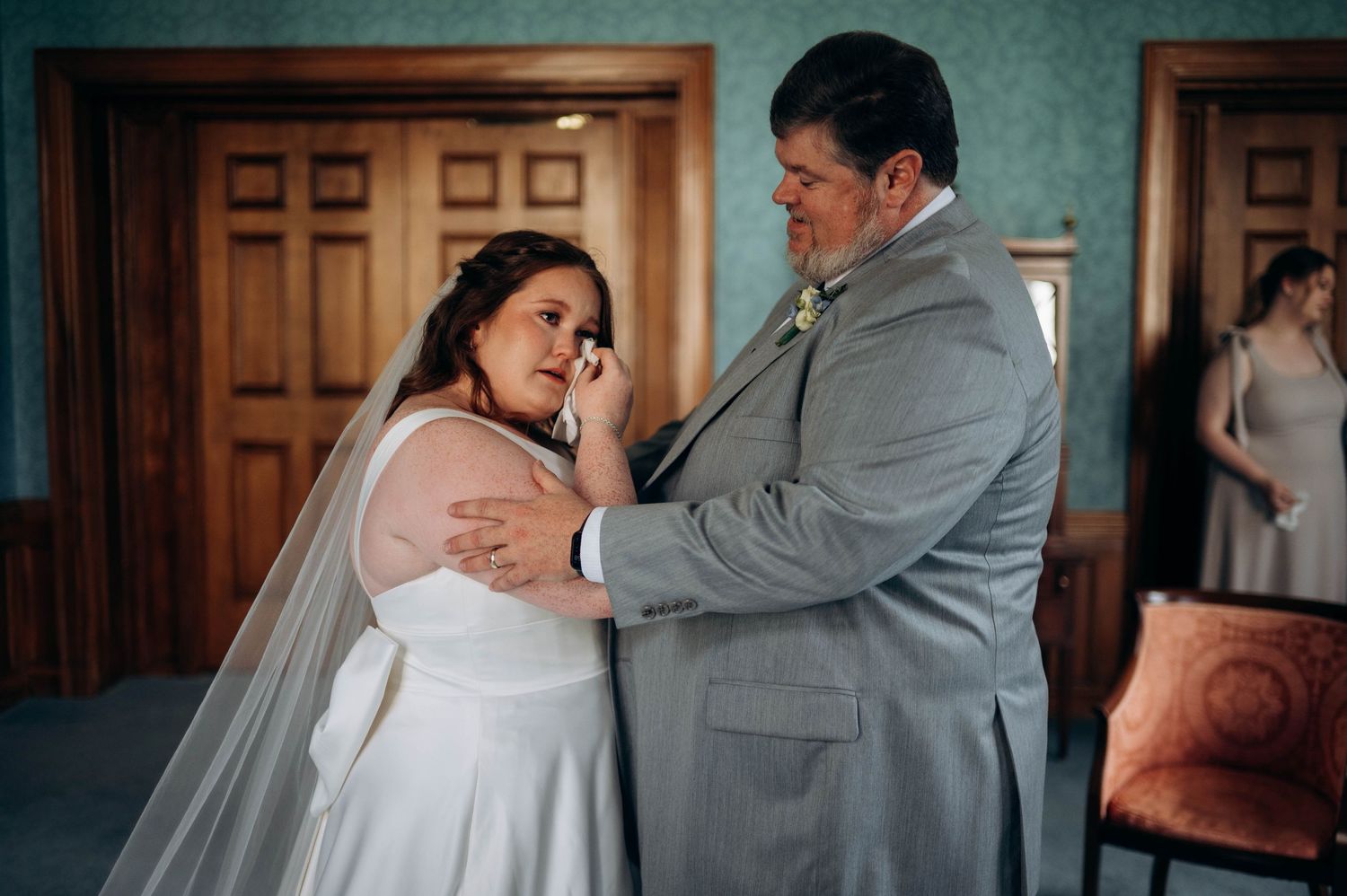 Wedding couple shares intimate moment in dimly lit indoor setting.